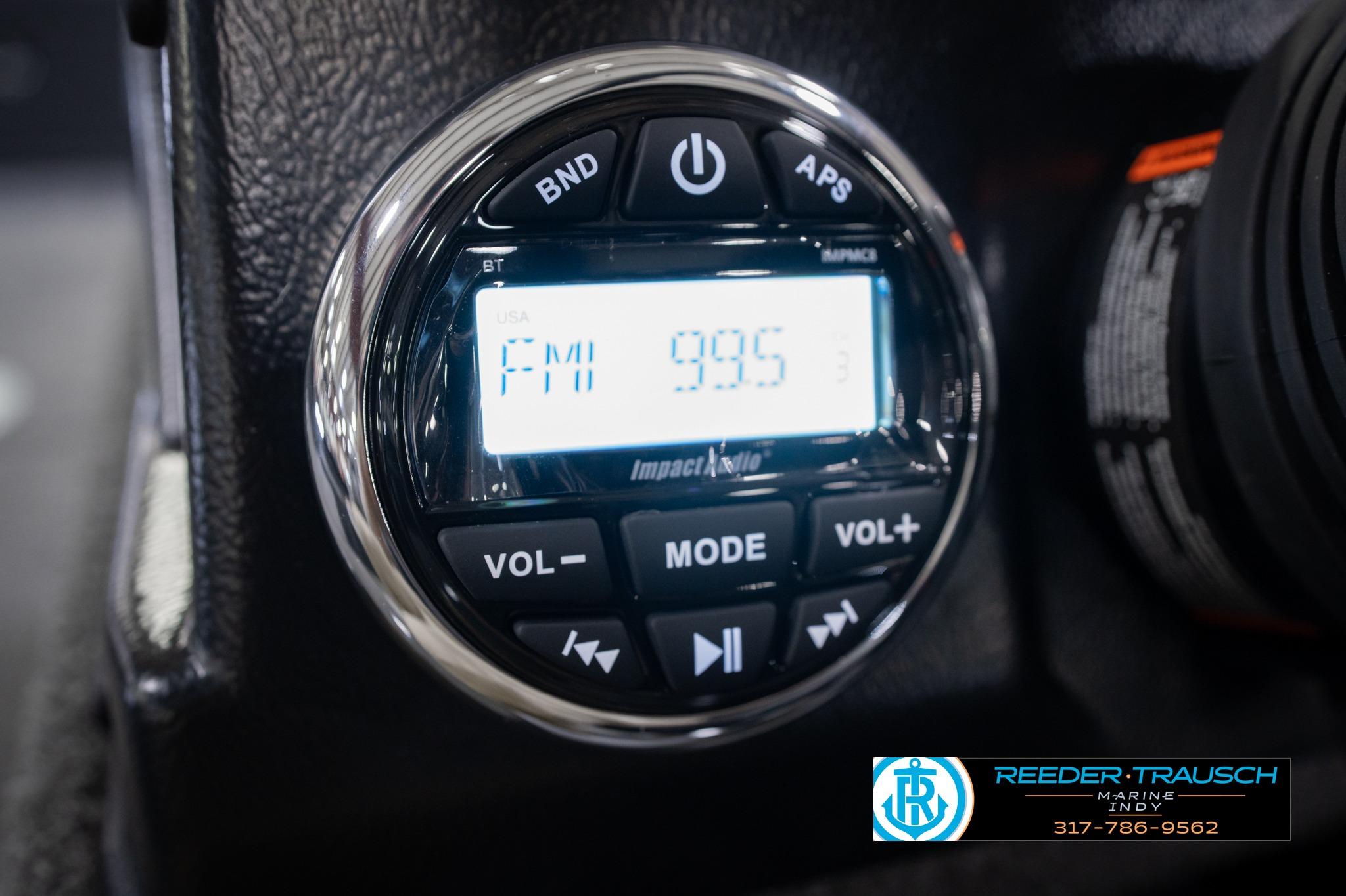 Close-up of a 2026 Lund 1775 Impact XS SS boat radio display showing FM 99.5.