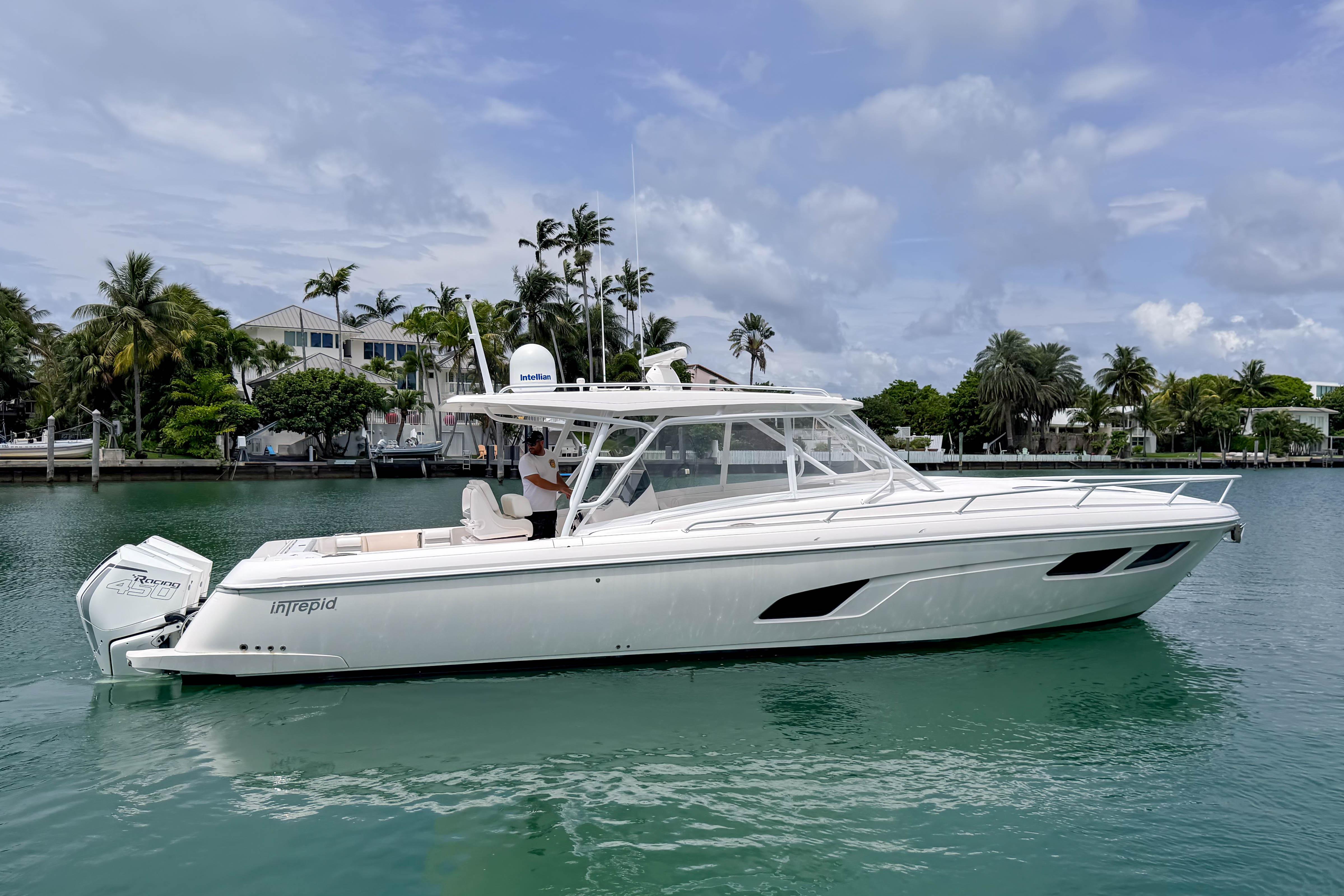 2021 Intrepid 409 Valor yacht on calm water, surrounded by tropical scenery.