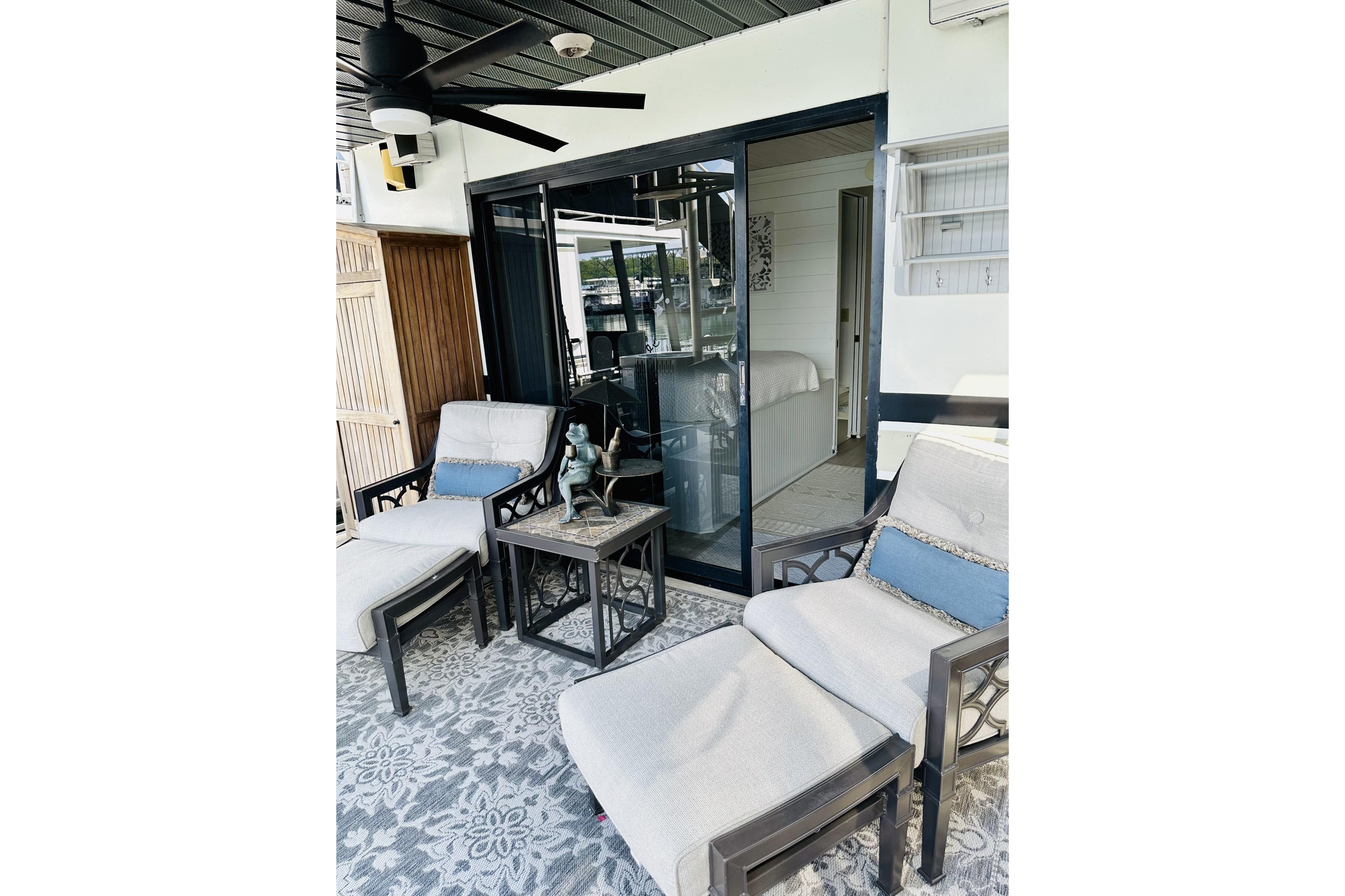 Outdoor seating area on a 1992 Sumerset 66 houseboat with cushioned chairs and a ceiling fan.
