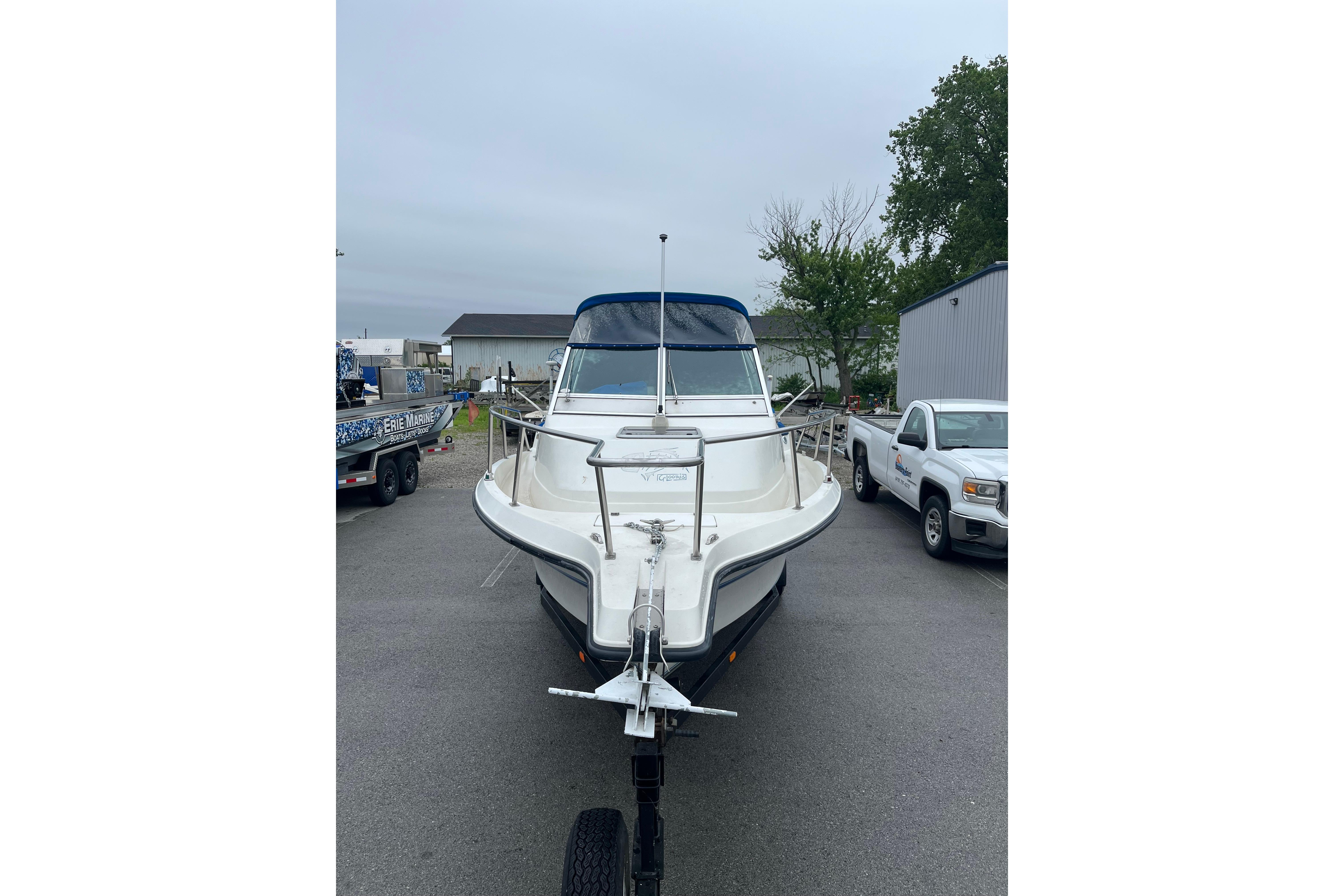 1995 Celebrity 2500 Fish Hawk boat on trailer in parking lot.