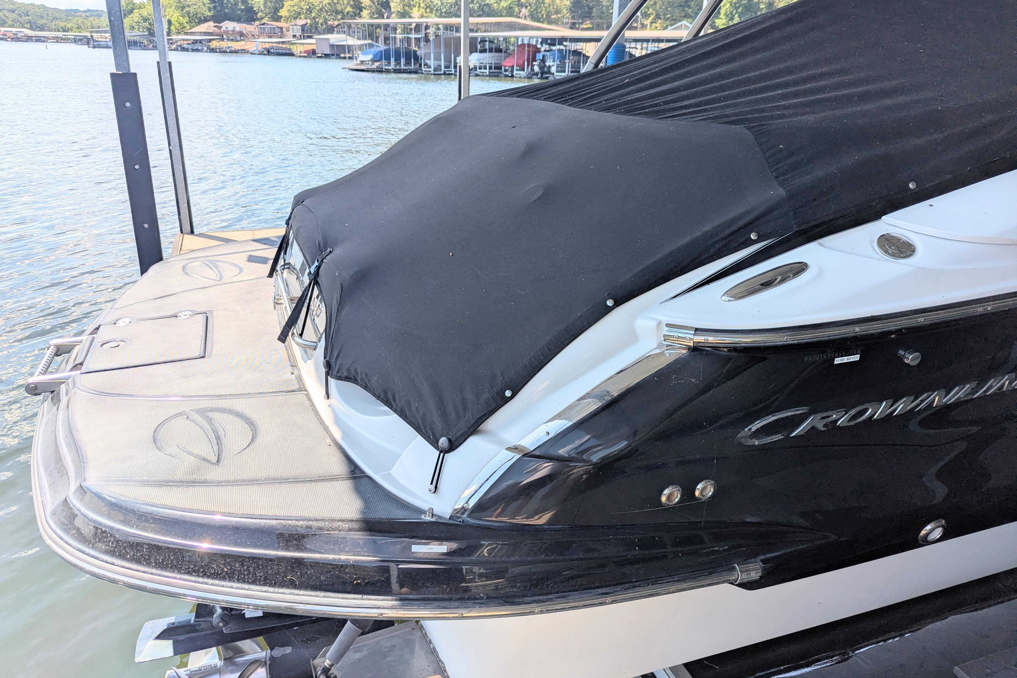 2008 Crownline 300 LS boat docked with black cover, scenic waterfront background.