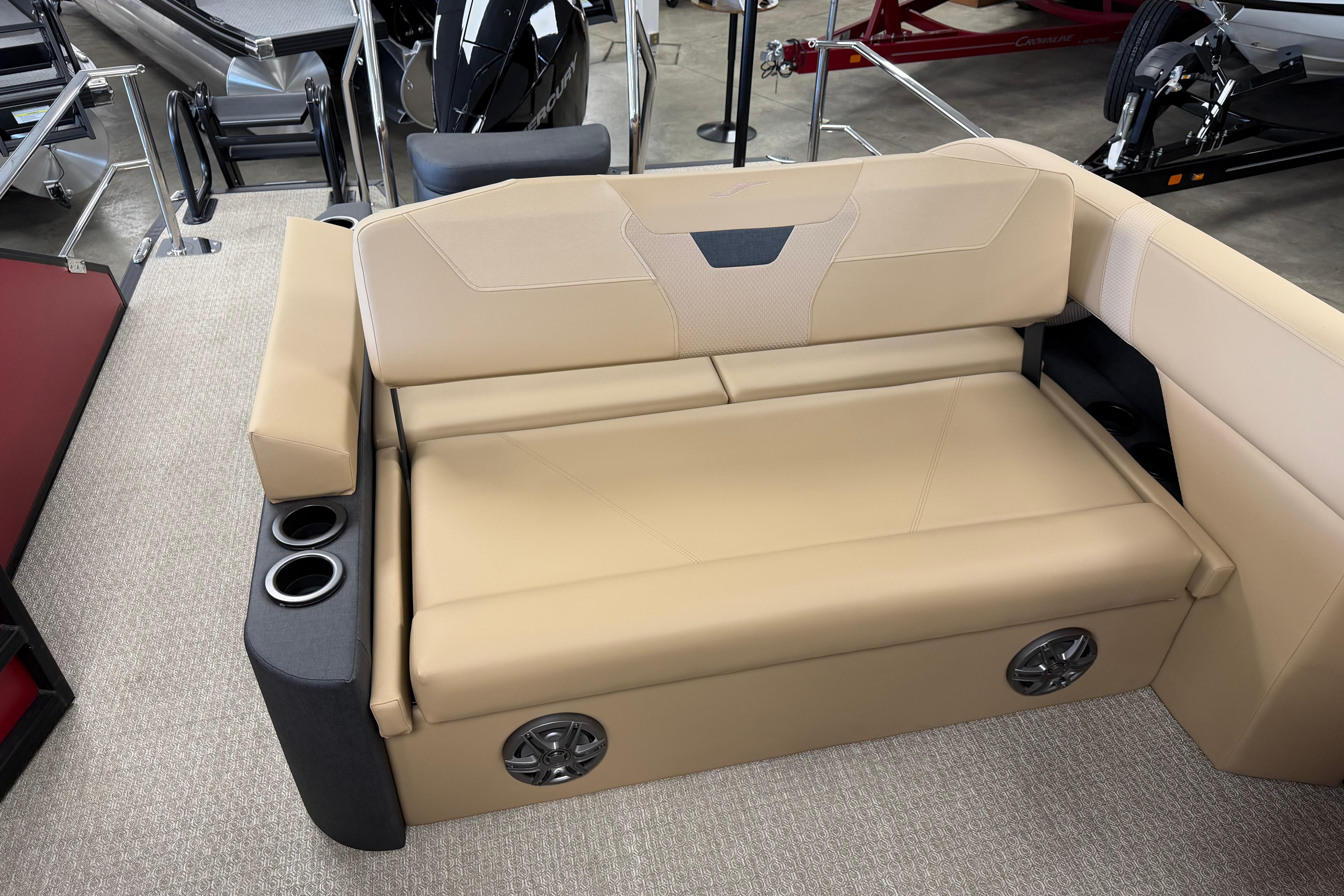 Luxurious beige seating on 2026 Evotti 523CS boat, featuring cup holders and integrated speakers.