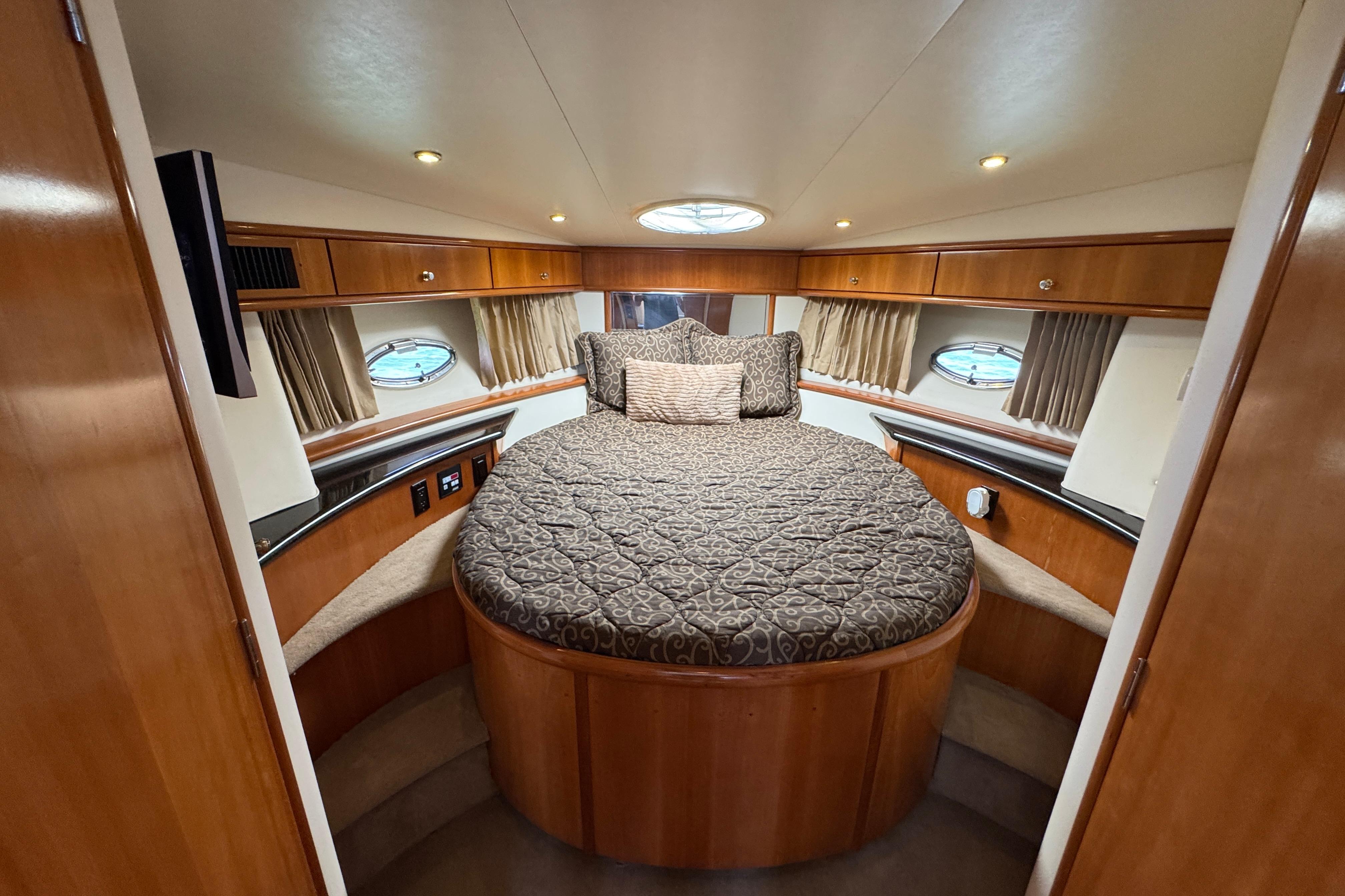 Luxurious 2002 Carver 396 Motor Yacht bedroom with elegant wood finish and circular bed.