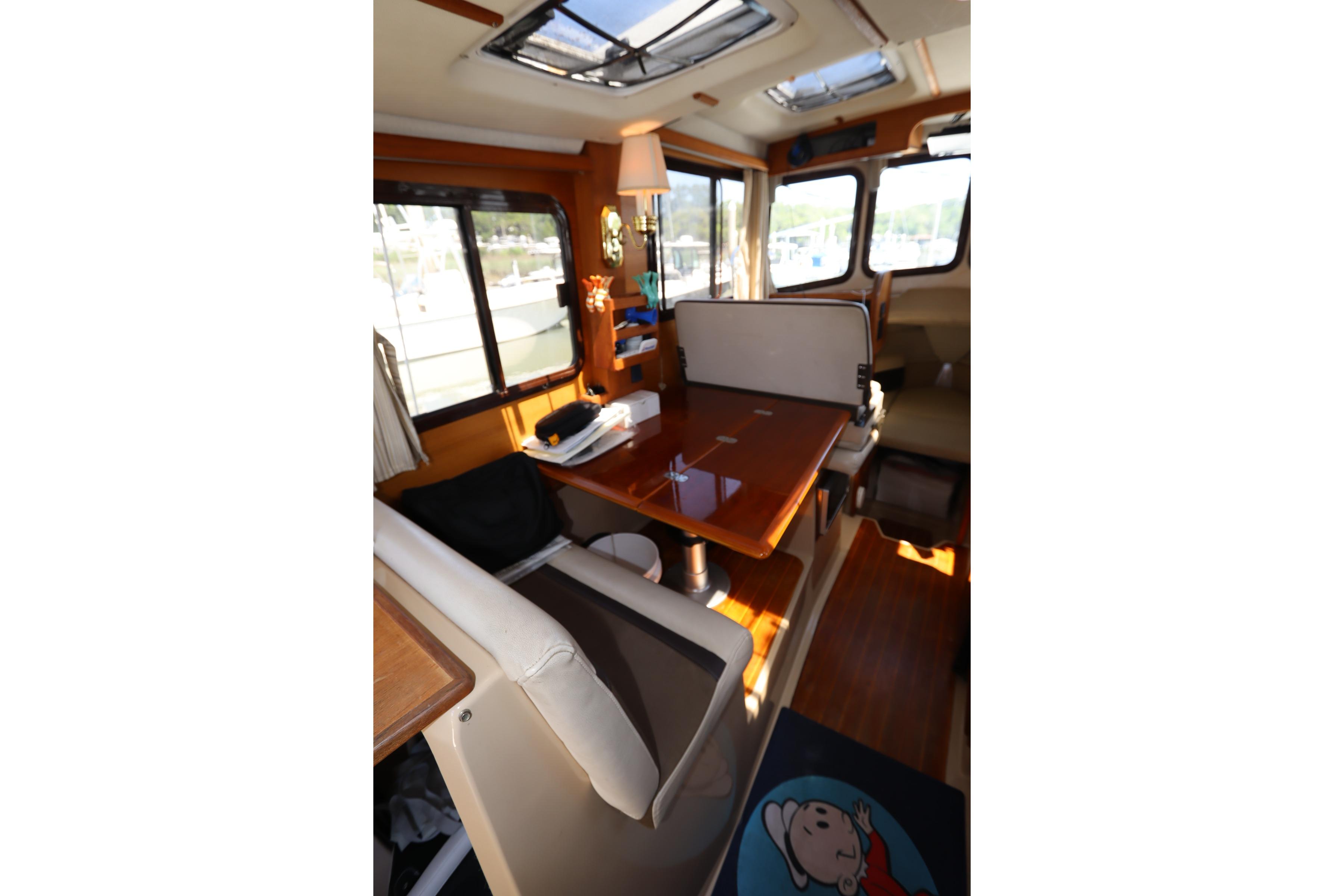 Interior of 2015 Ranger Tugs R-27 boat with dining area and windows.