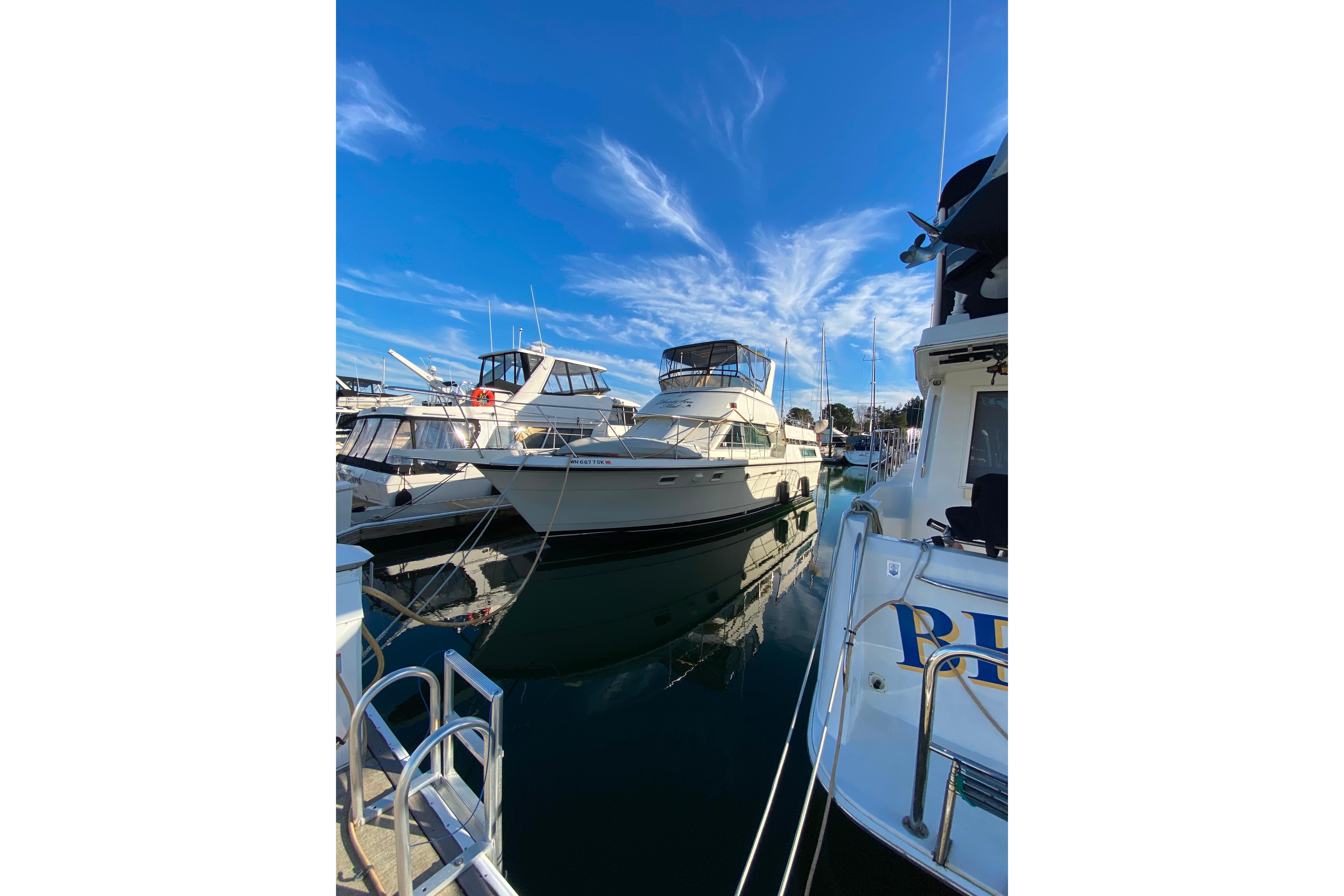 1988 Hatteras 40 Double Cabin yacht docked in a marina under a clear blue sky.