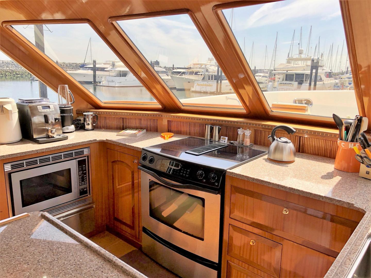Luxurious kitchen interior of 2027 Legend 760 Skybridge yacht with marina view.