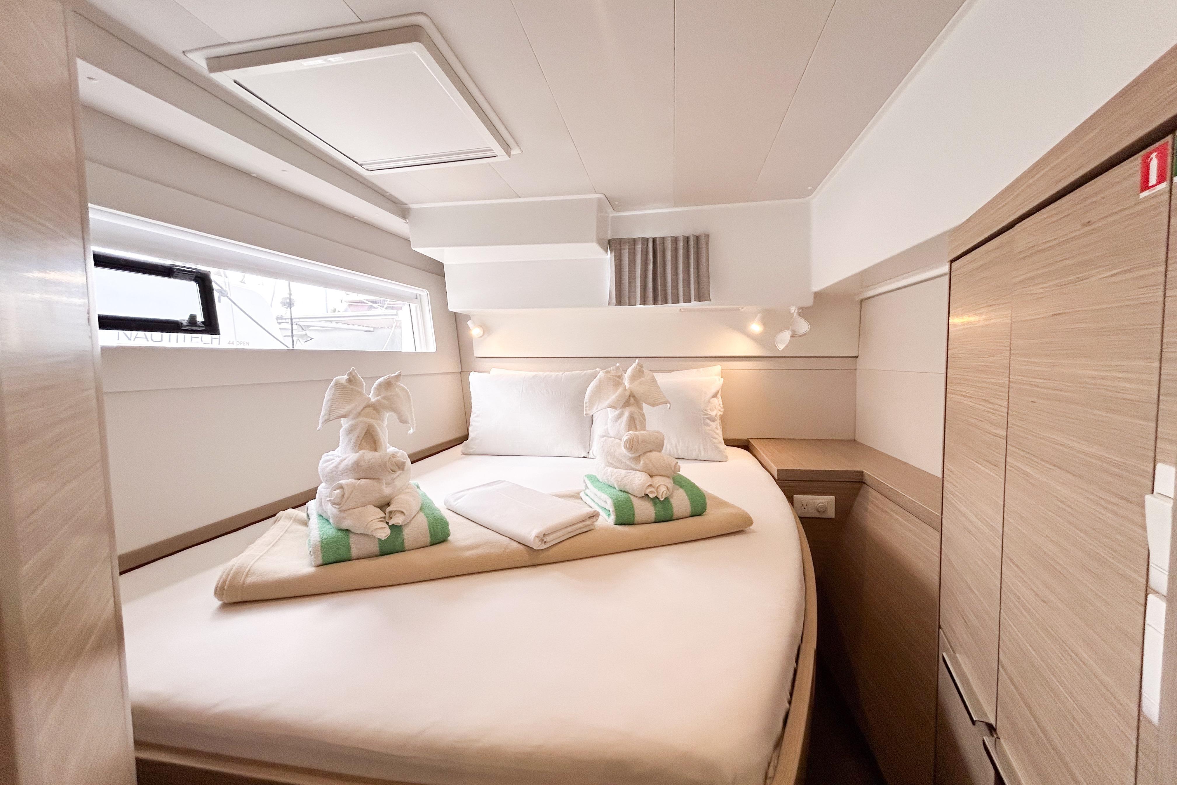 Luxurious cabin interior of 2025 Lagoon 40 catamaran with elegant bedding and towel art.