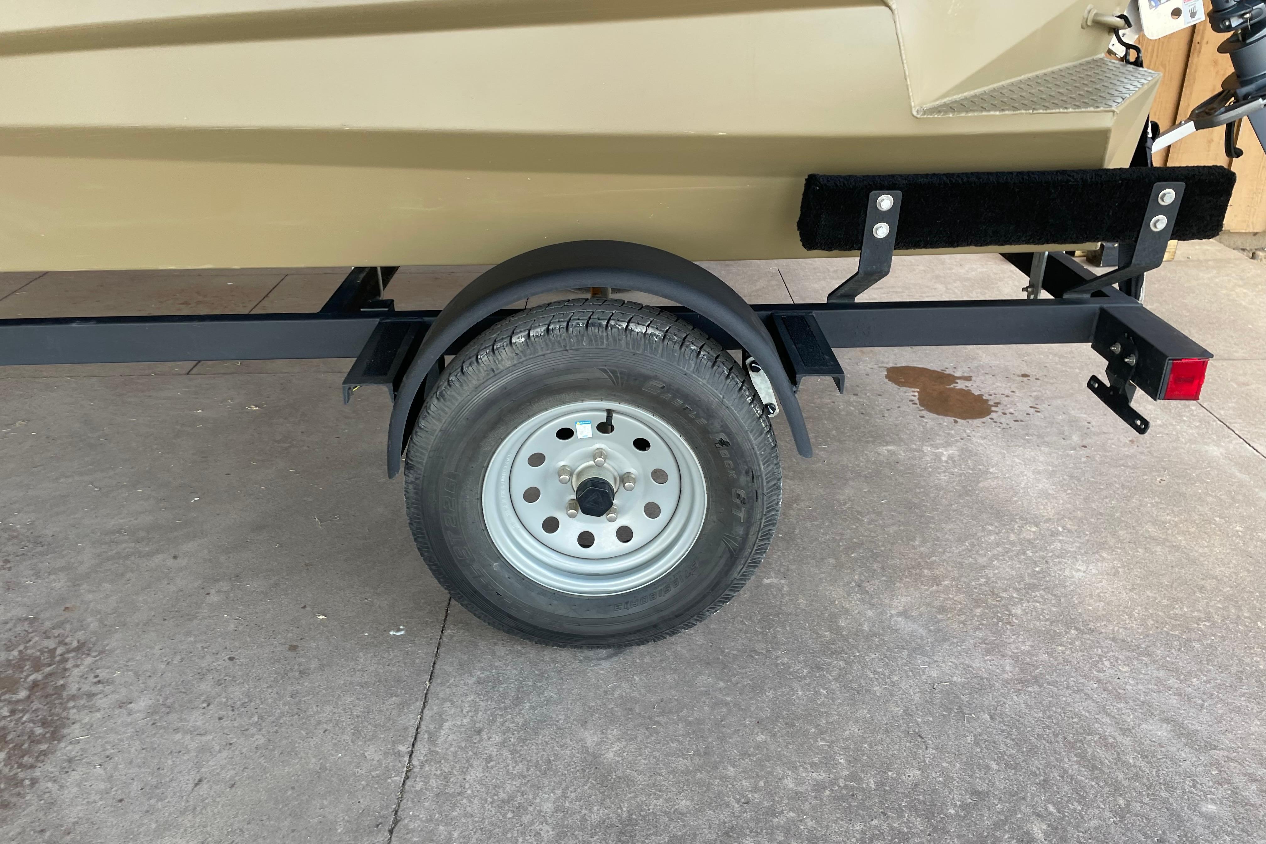 Trailer wheel of 2025 Edge Duck Boats 550 on concrete surface.