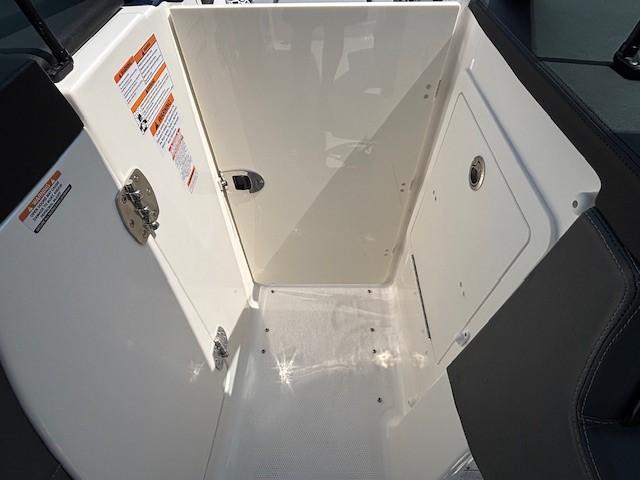 Interior view of 2026 Chaparral SSX 6 boat compartment with storage and safety labels.