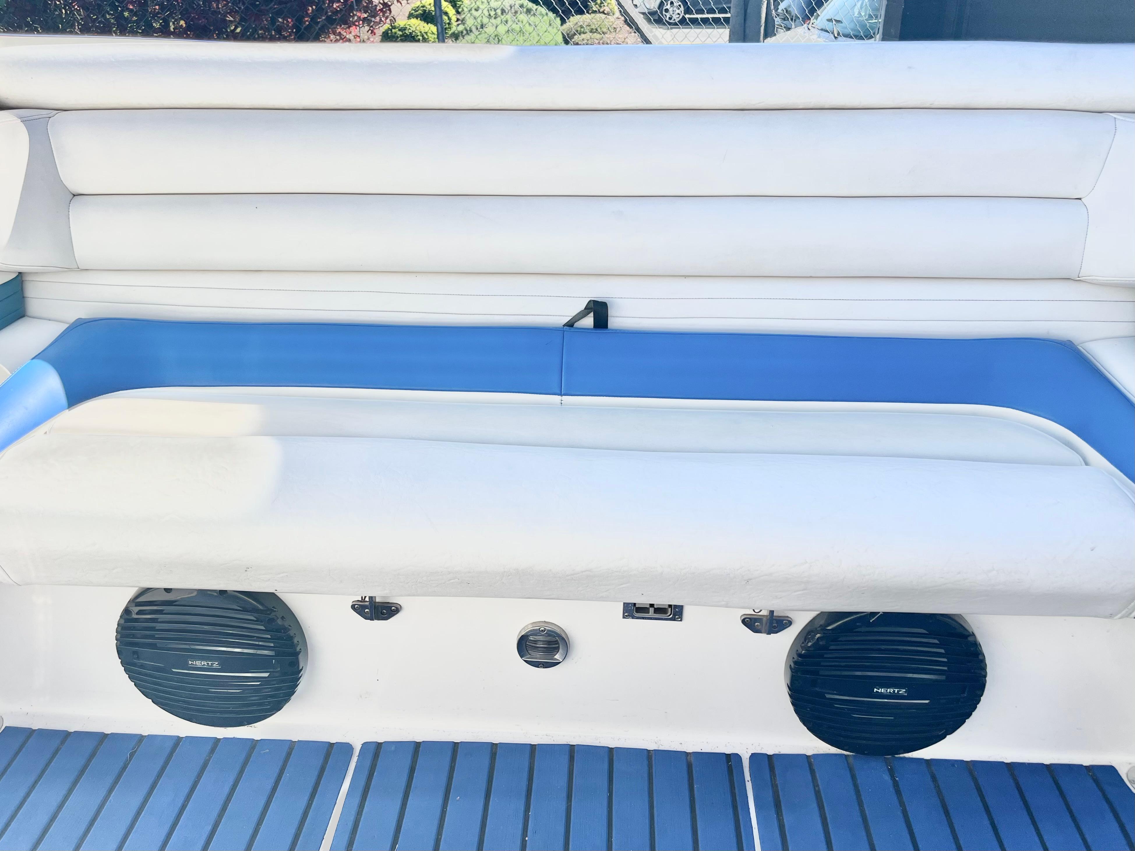 1999 Fountain 38 Sport Cruiser interior with white and blue seating, featuring built-in speakers.
