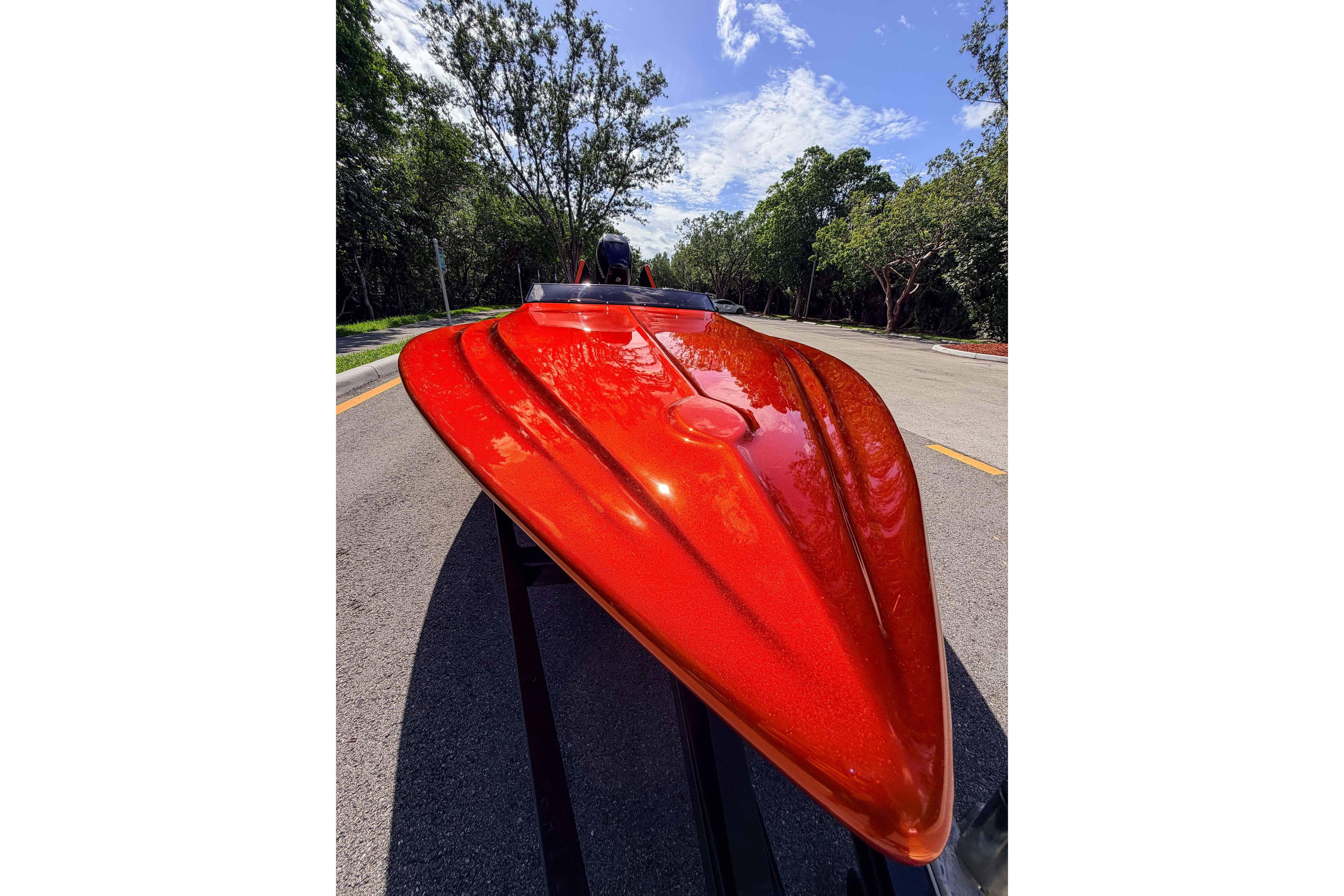 1984 Sleekcraft Aristocrat 20 boat with vibrant red finish on a sunny road.
