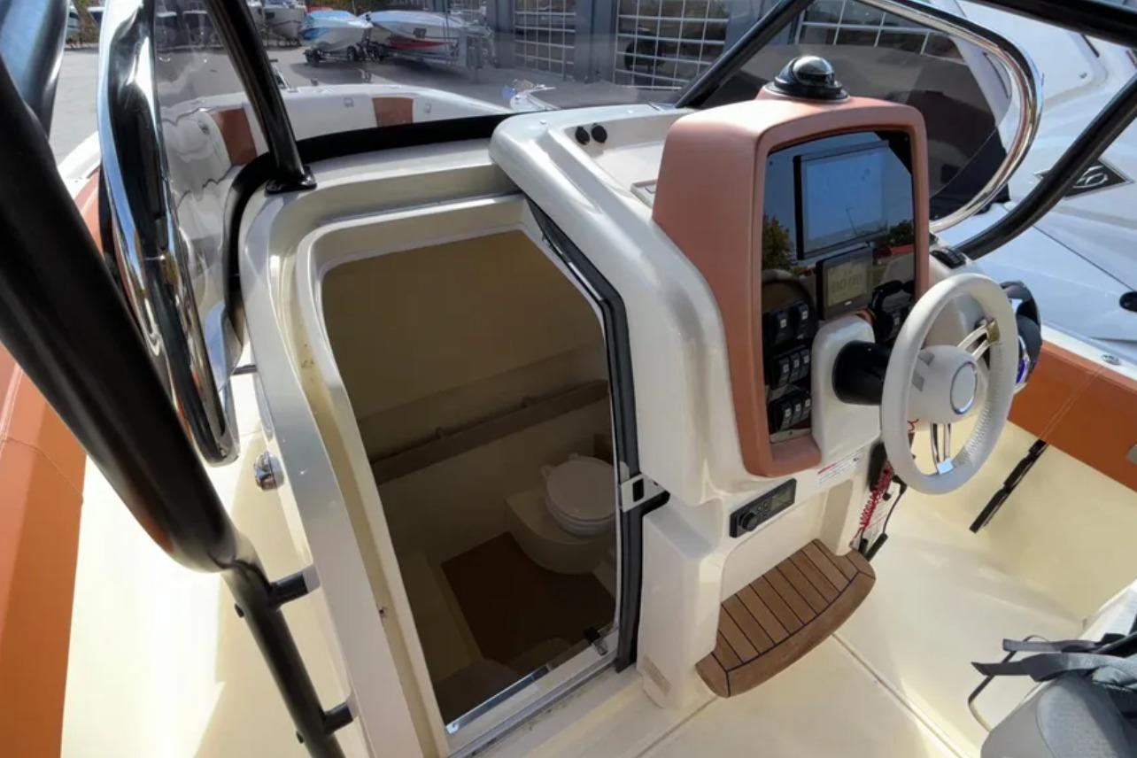2024 Capoforte FX270 boat helm with steering wheel and cabin entrance.