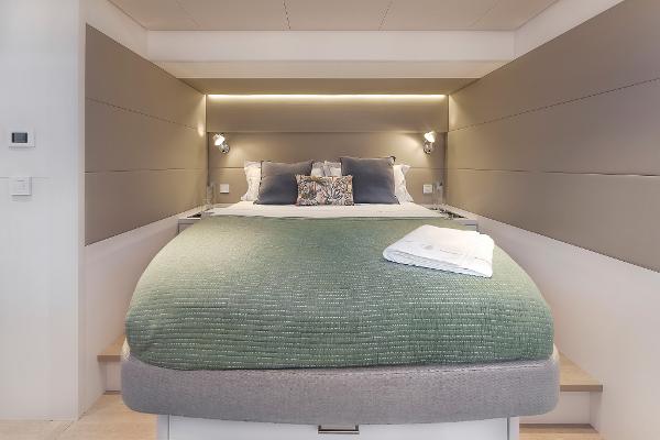 Luxurious bedroom interior of 2025 Lagoon SIXTY 5 yacht with modern design and cozy bedding.