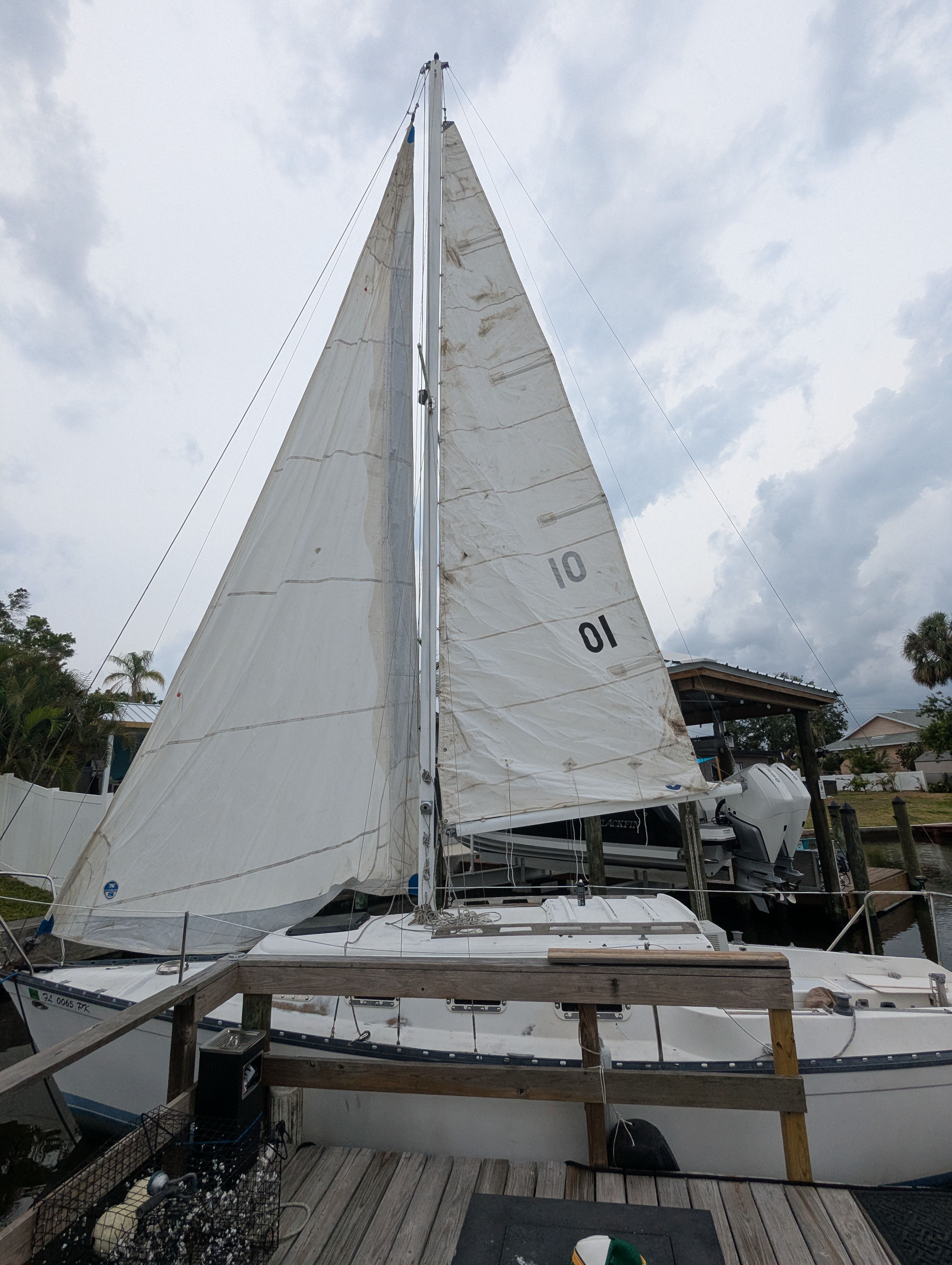 A 1982 Hunter 25.5 sailboat is docked. The sails are raised.