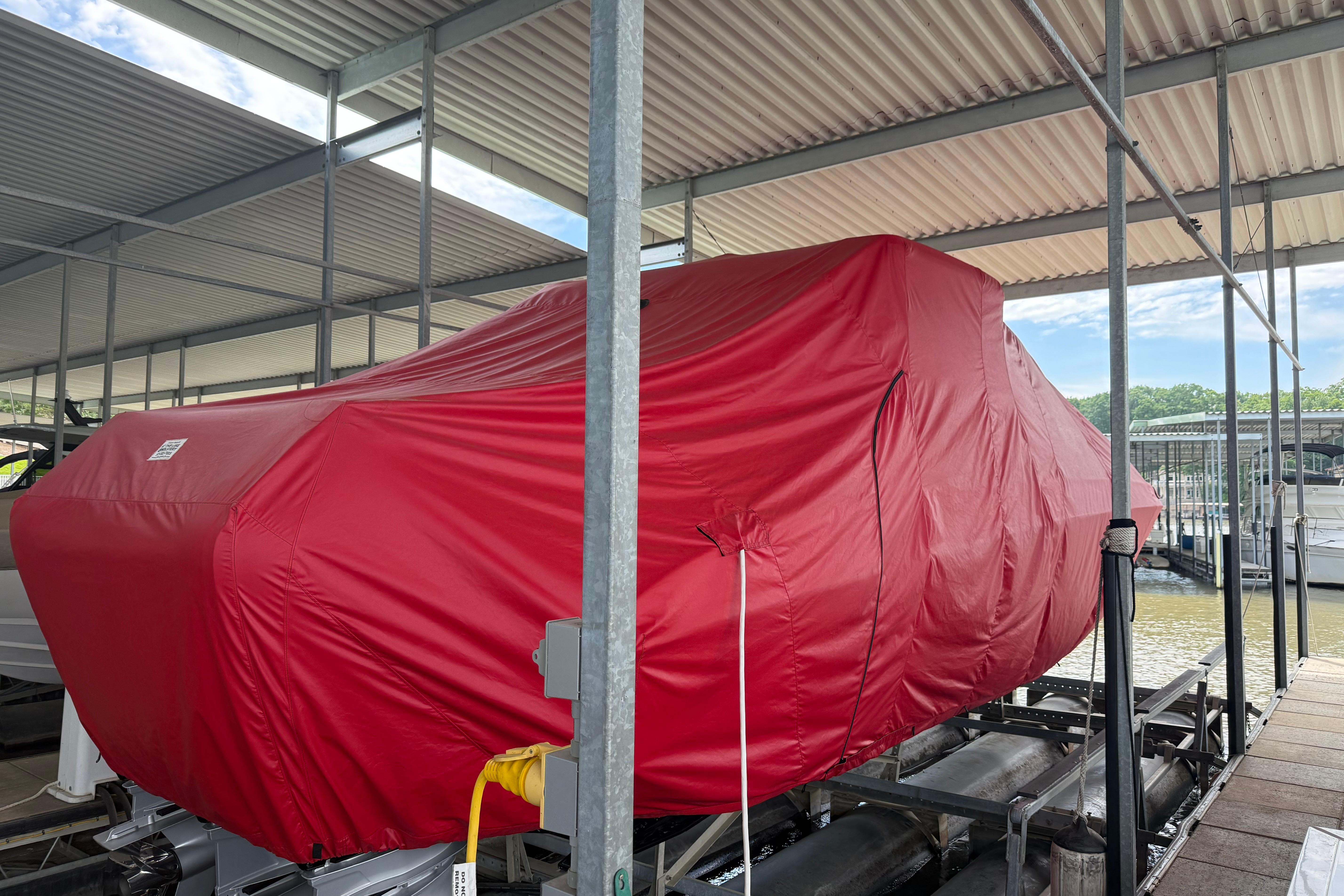 2025 Fountain 38 SCX boat covered in red tarp at marina dock.
