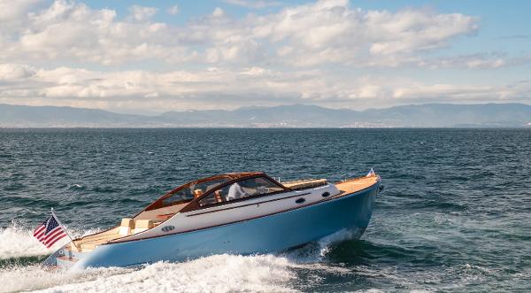 2023 Vento V40 Retro Classic Open boat cruising on the ocean with mountains in the background.