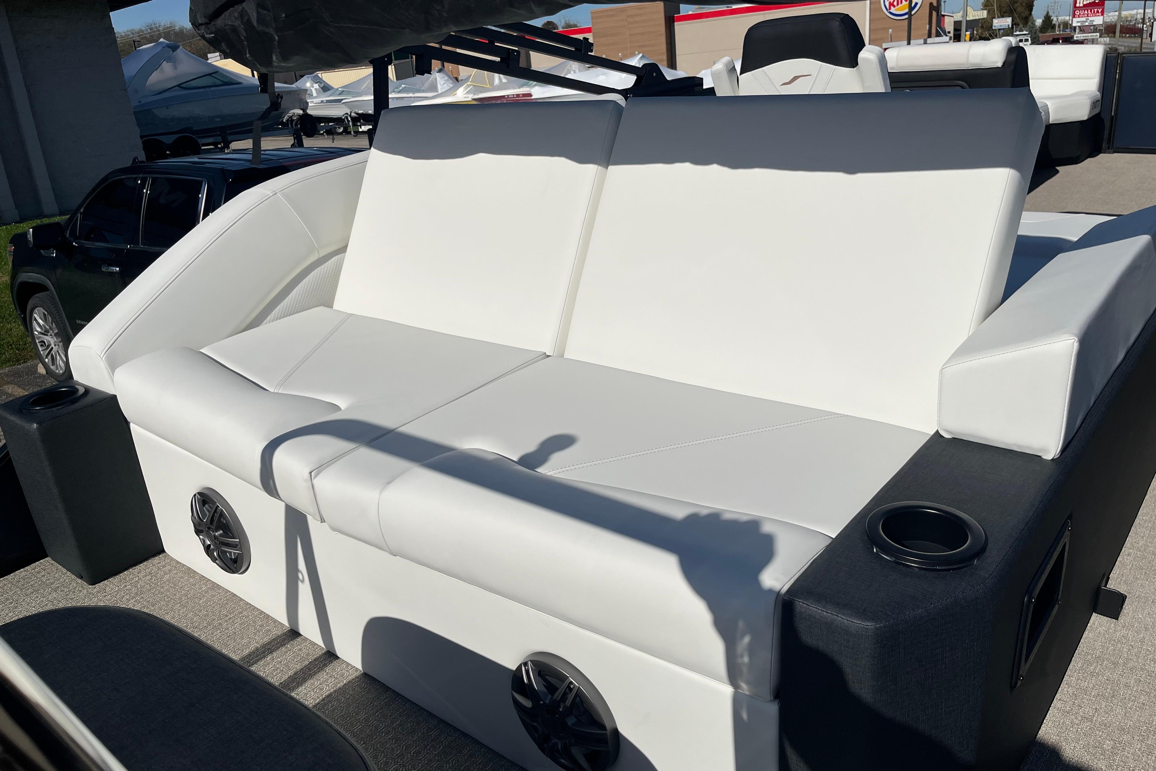 Luxurious white seating on 2026 Evotti 523CS boat, featuring built-in speakers and cup holders.