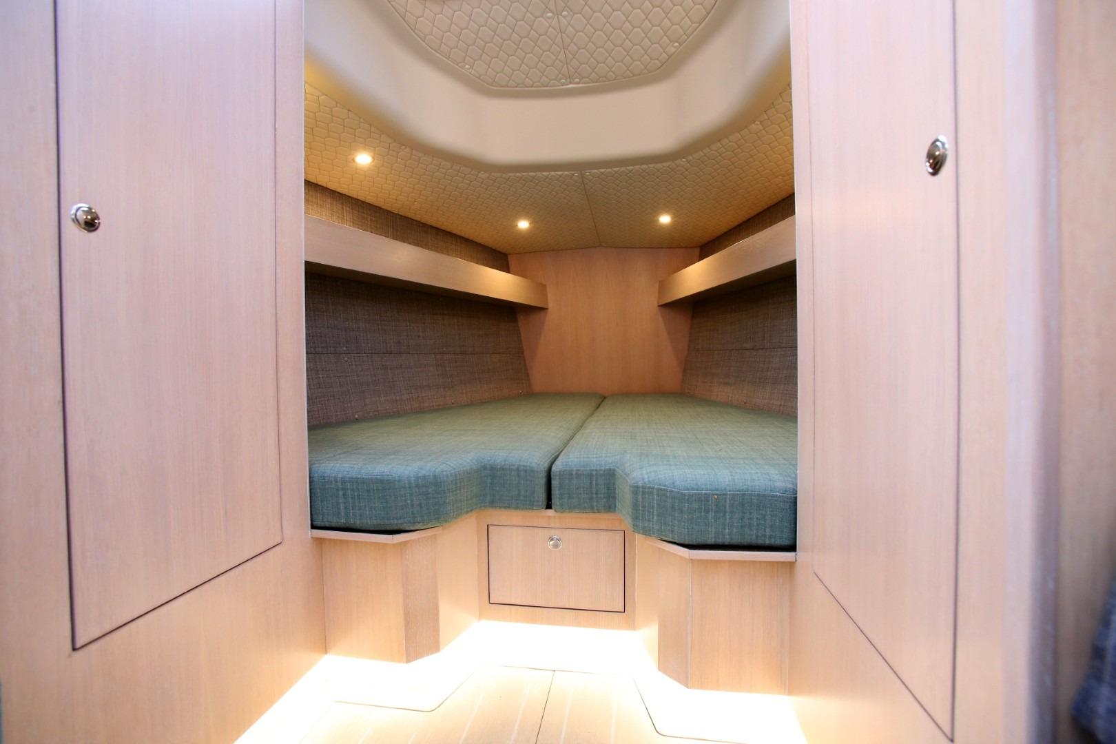 Luxurious cabin interior of 2025 Shogun 43 yacht with cozy bedding and ambient lighting.