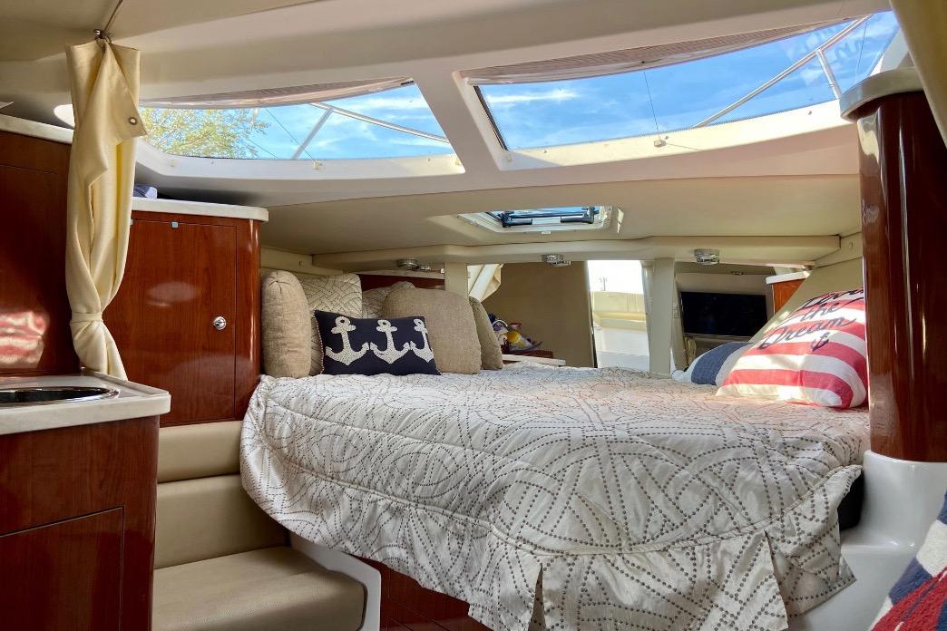 Luxurious interior cabin of 2012 Regal 35 Express Cruiser with skylight and nautical decor.