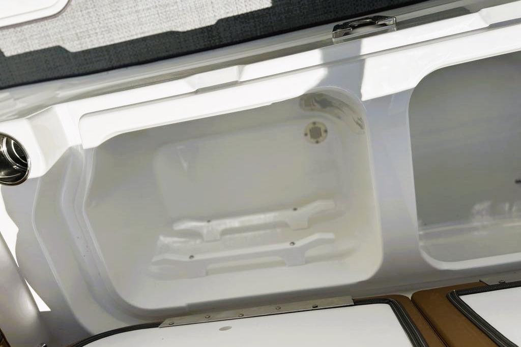 Storage compartment of 2026 Tahoe 2150 boat, featuring sleek white interior design.