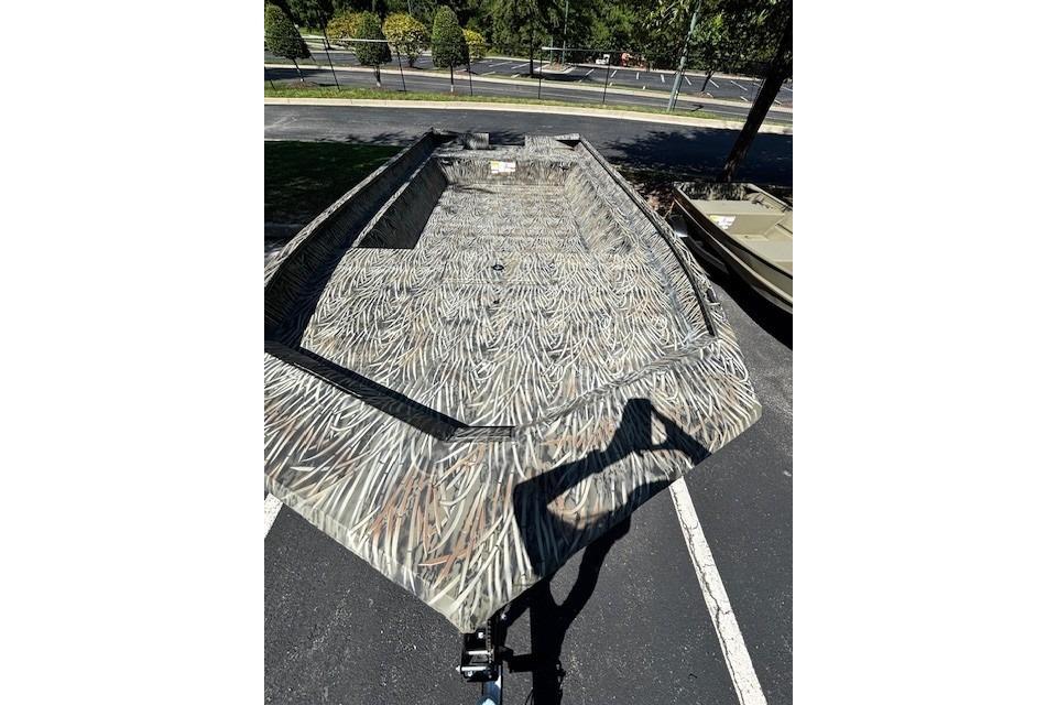 2026 Tracker Grizzly 2072 Utility boat with camouflage pattern in a parking lot.