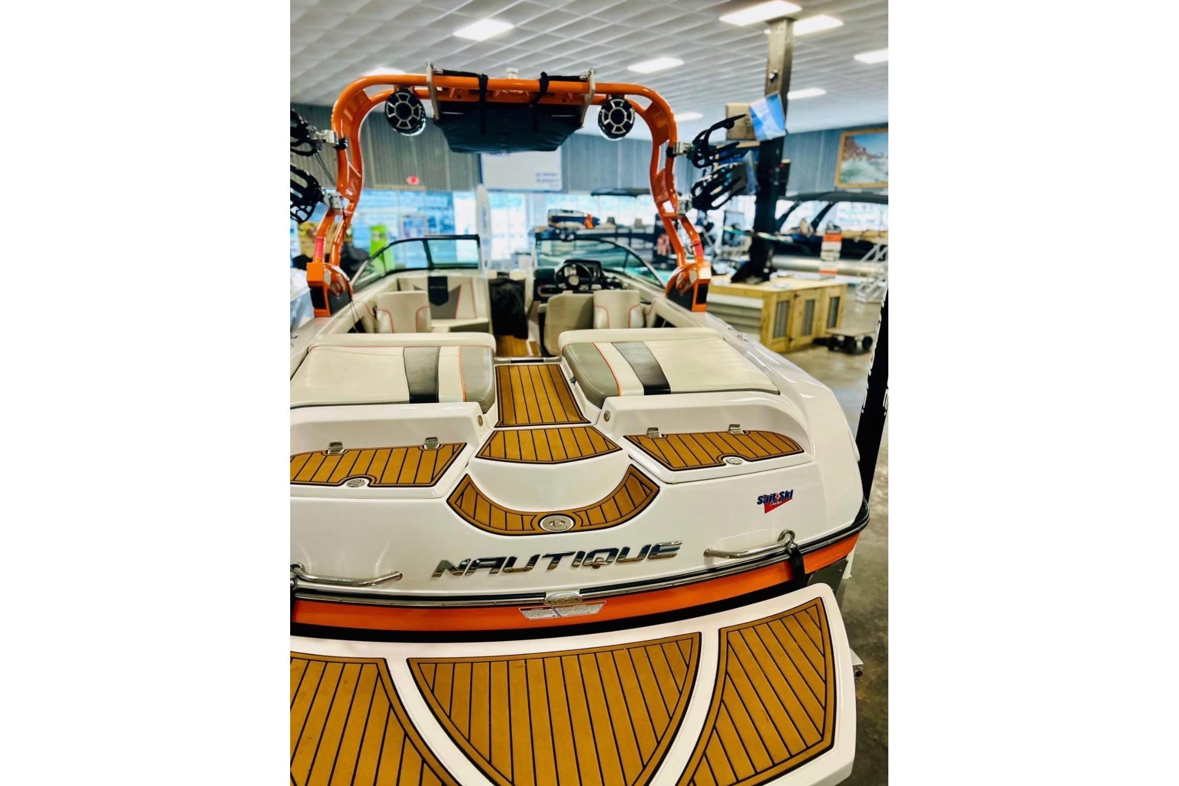 2013 Nautique Super Air Nautique 230 boat interior with teak flooring in showroom.
