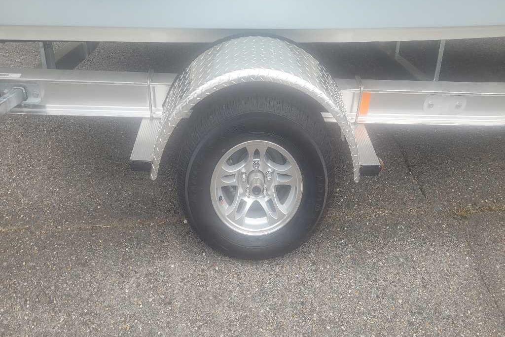 Trailer wheel of 2026 Mako 18 Pro Skiff on pavement.