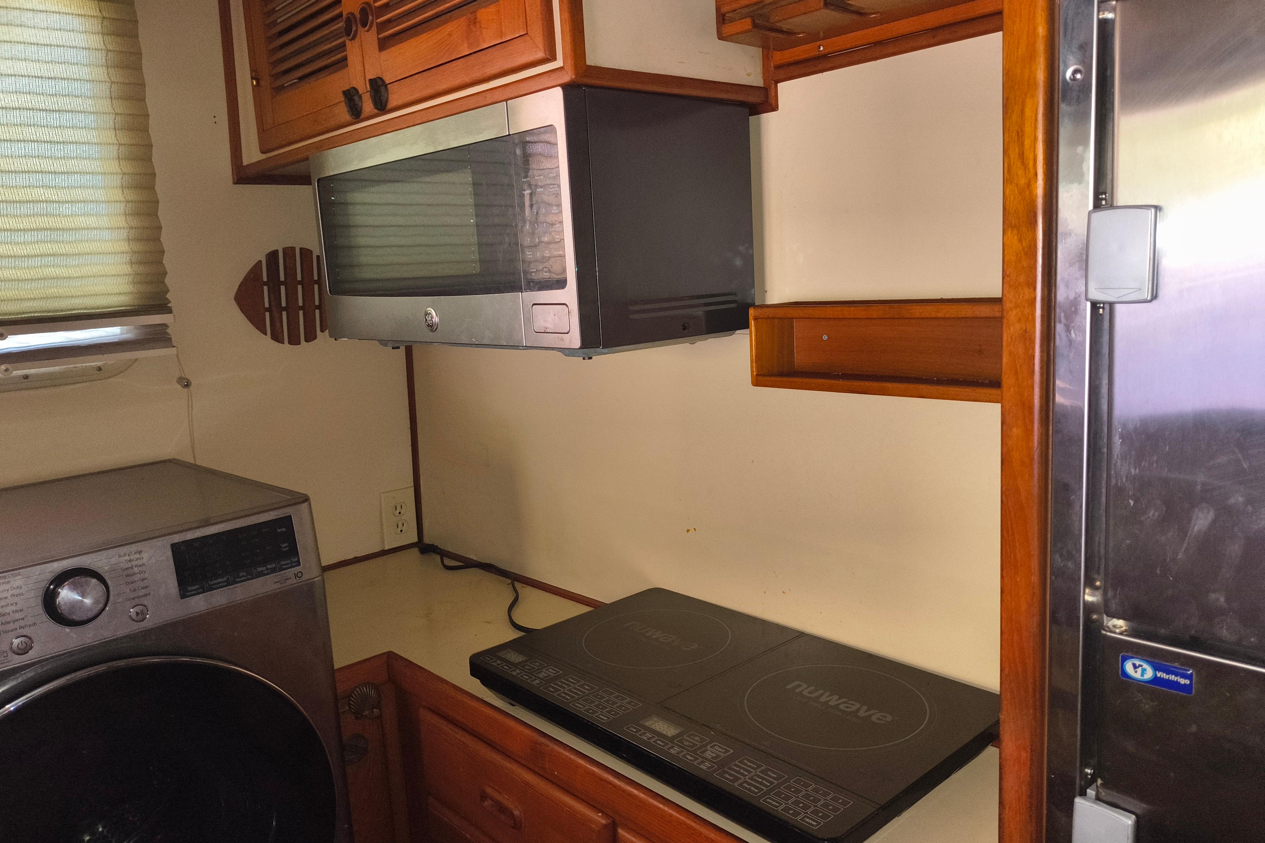 Compact kitchen area in a 1984 Kadey-Krogen Manatee with appliances and wooden cabinetry.