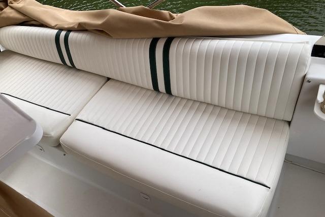 White cushioned seating on 2000 Mainship 430 Trawler, featuring striped upholstery and beige cover.