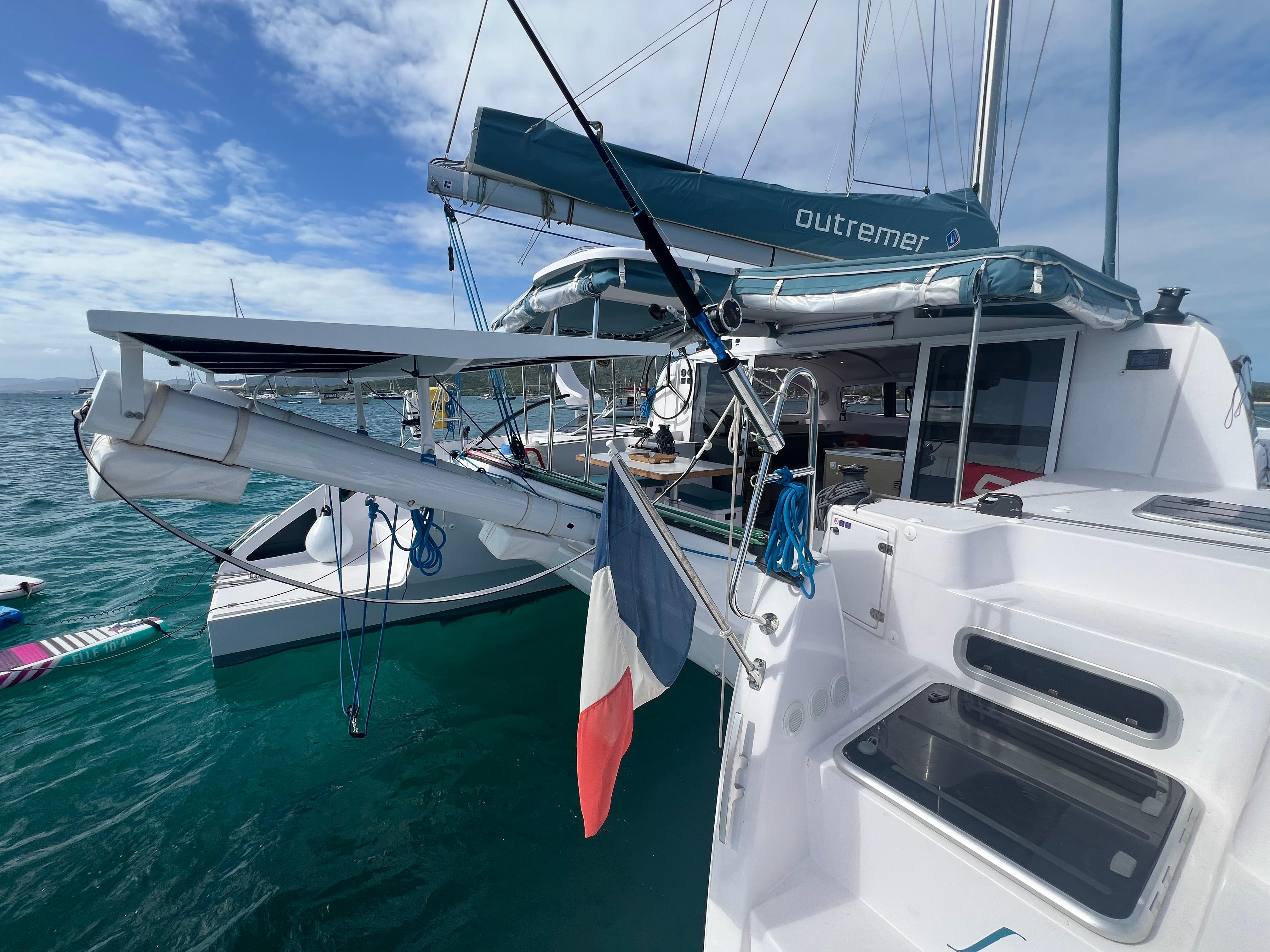 2024 Outremer 45 catamaran on water, featuring sails and French flag.