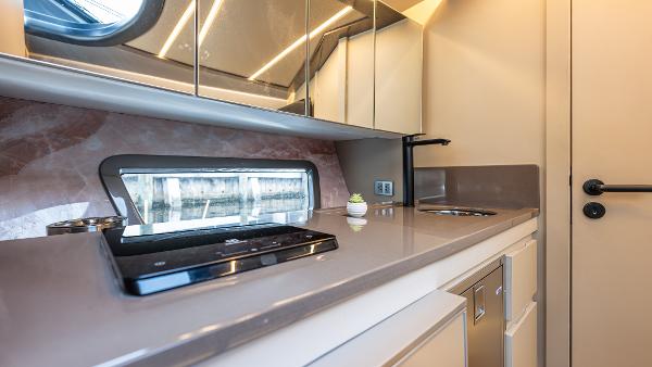 Modern kitchen interior in 2025 Hanover 415 RV with sleek countertops and appliances.