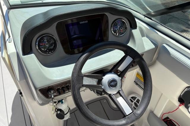 2023 Chaparral 21 SSi boat dashboard with steering wheel and gauges.