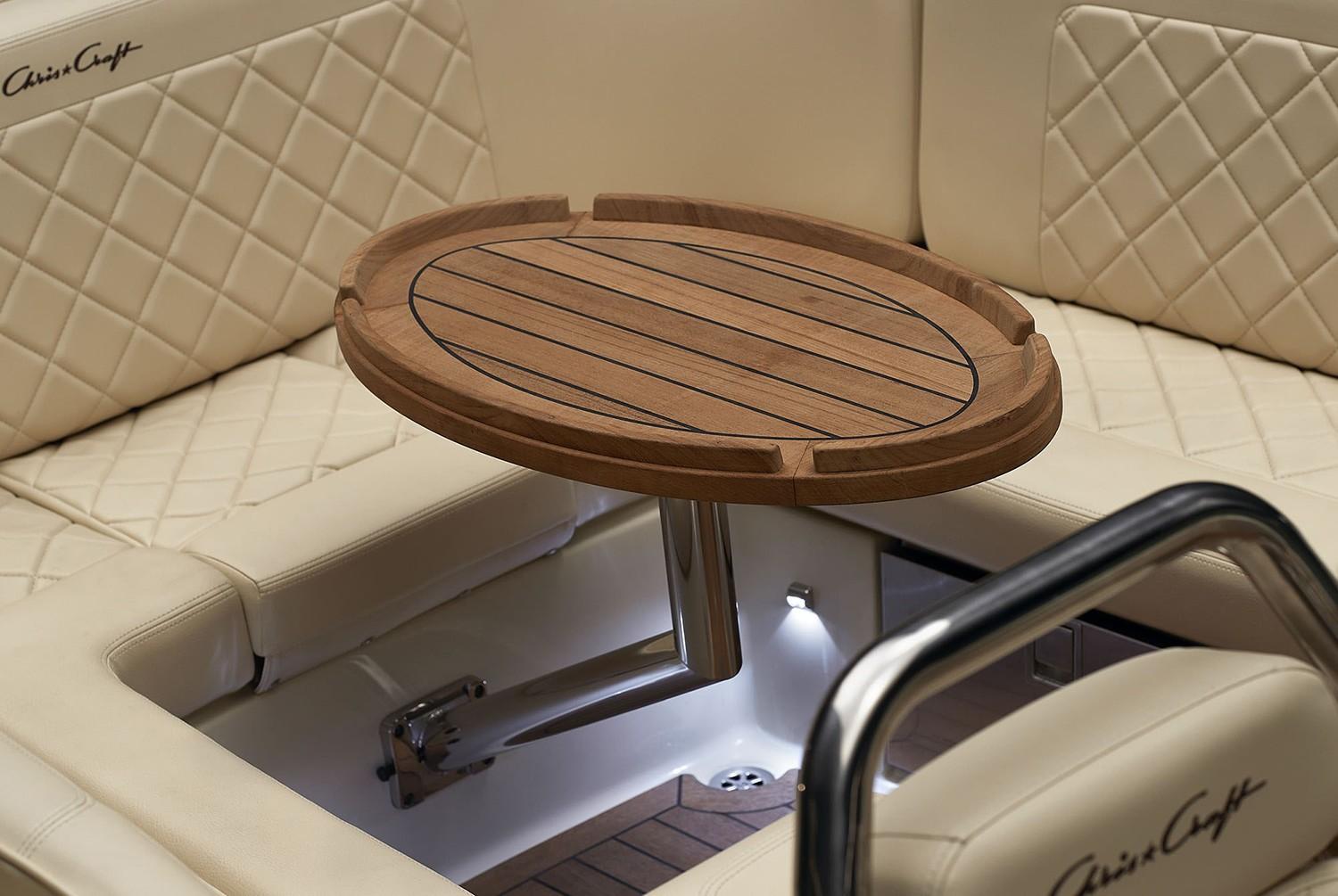 2023 Chris-Craft Launch 27 interior with wooden table and quilted seating.