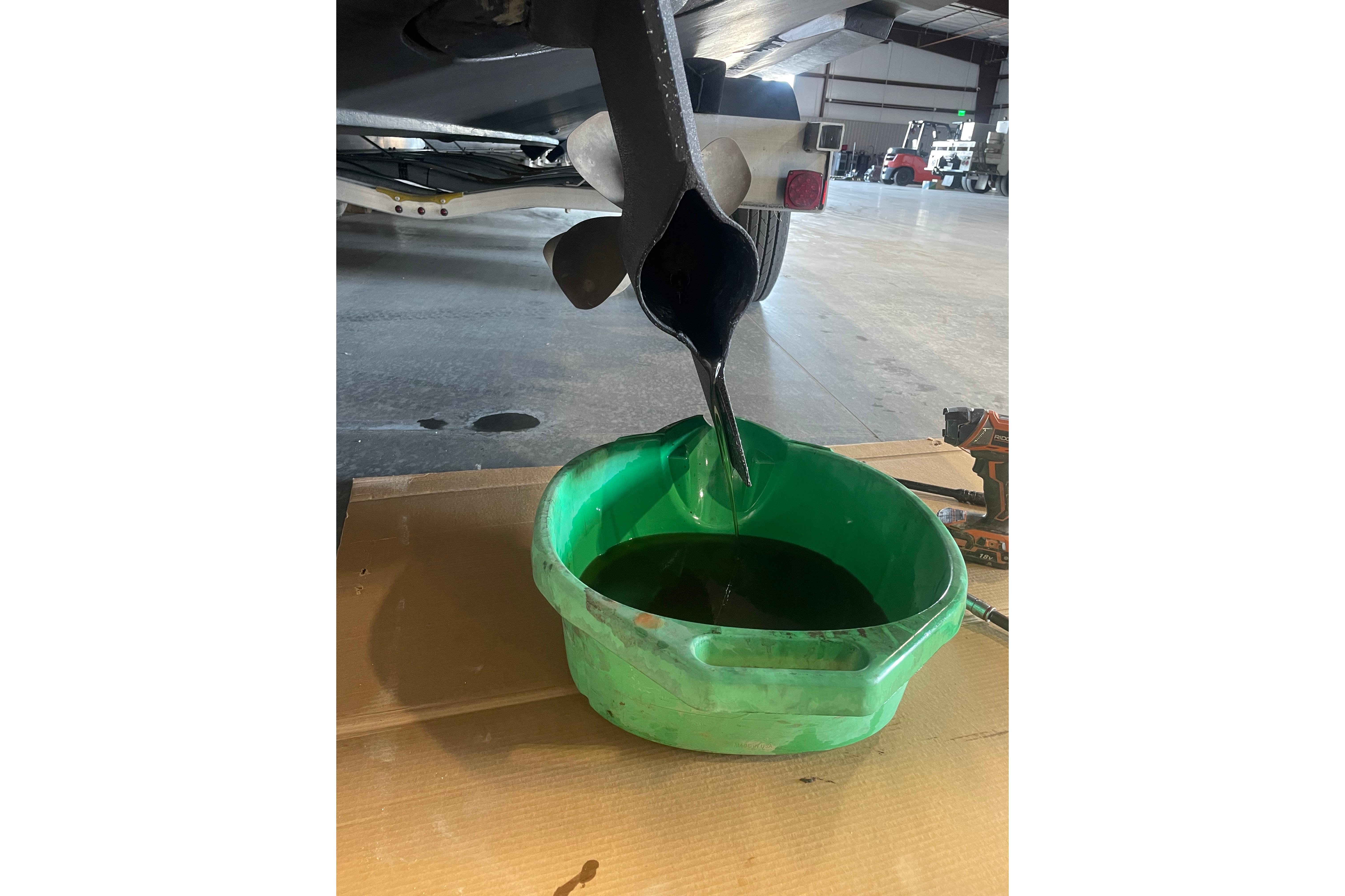 Oil draining from a 2011 Cruisers Yachts 390 Sports Coupe into a green container.
