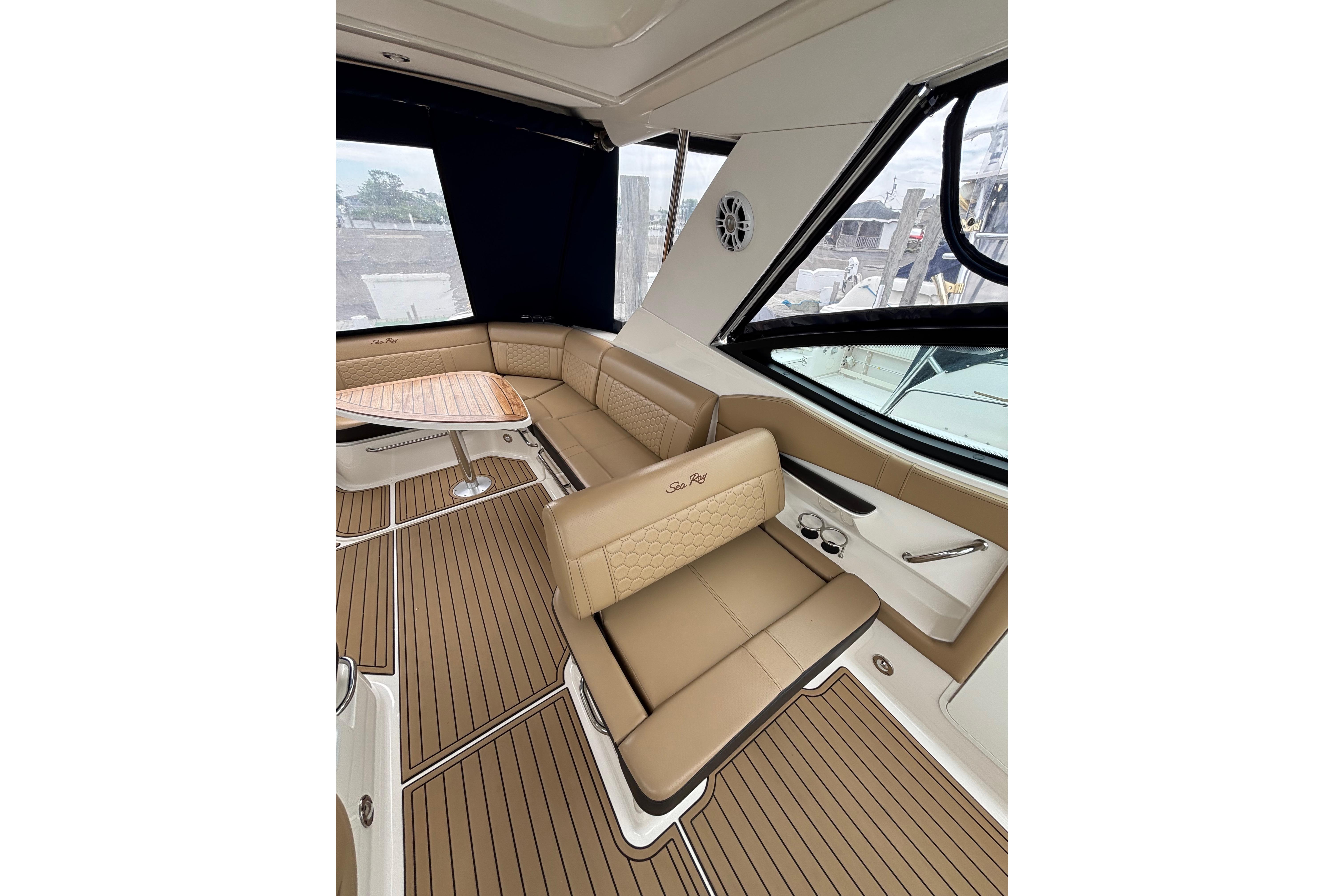 Luxurious interior of 2021 Sea Ray Sundancer 320 Outboard with tan seating and wood accents.