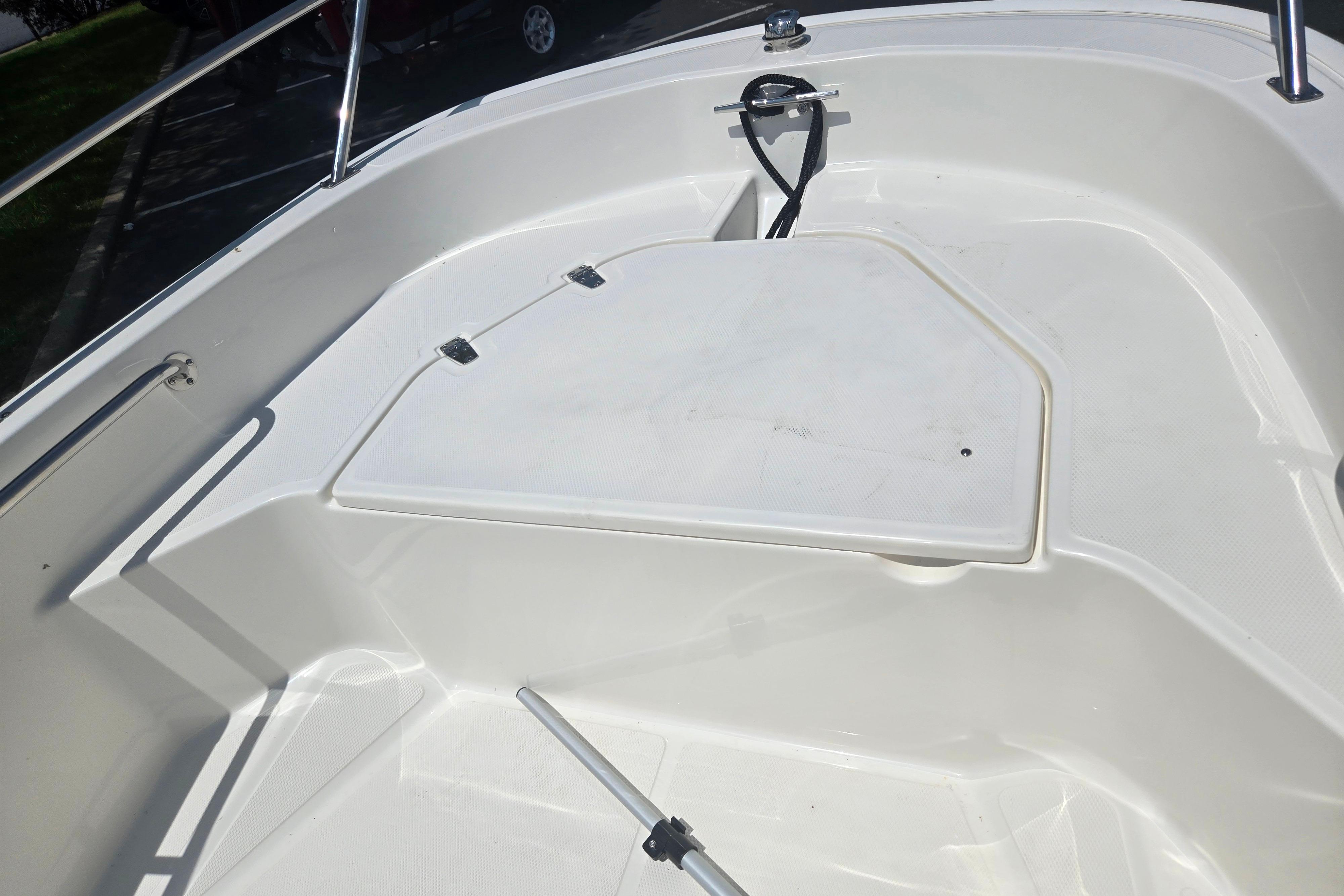 2025 Boston Whaler 130 Super Sport boat interior with storage compartment and railing.