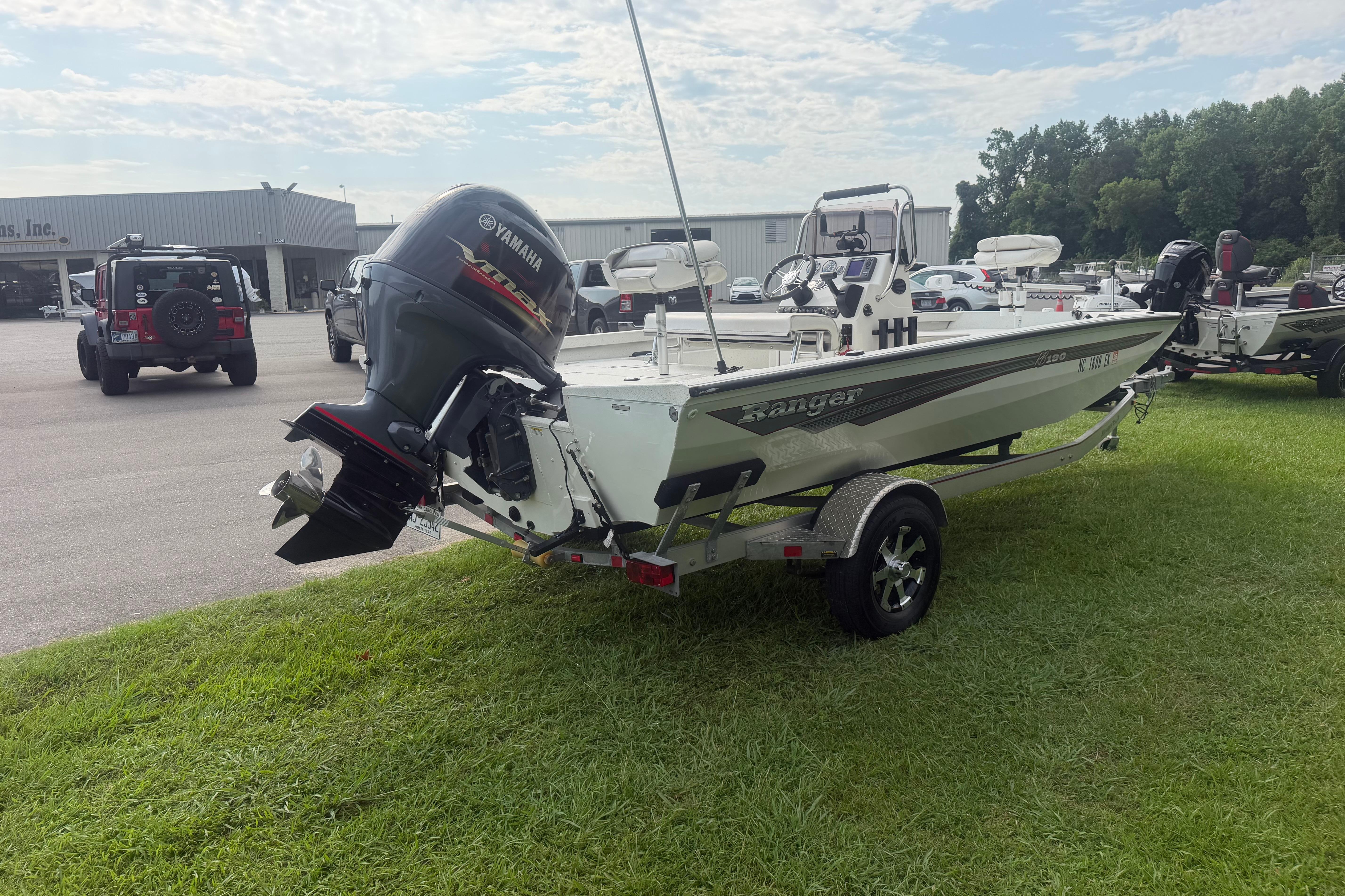 2018 Ranger RB190 boat with Yamaha motor on trailer, parked on grass near dealership.