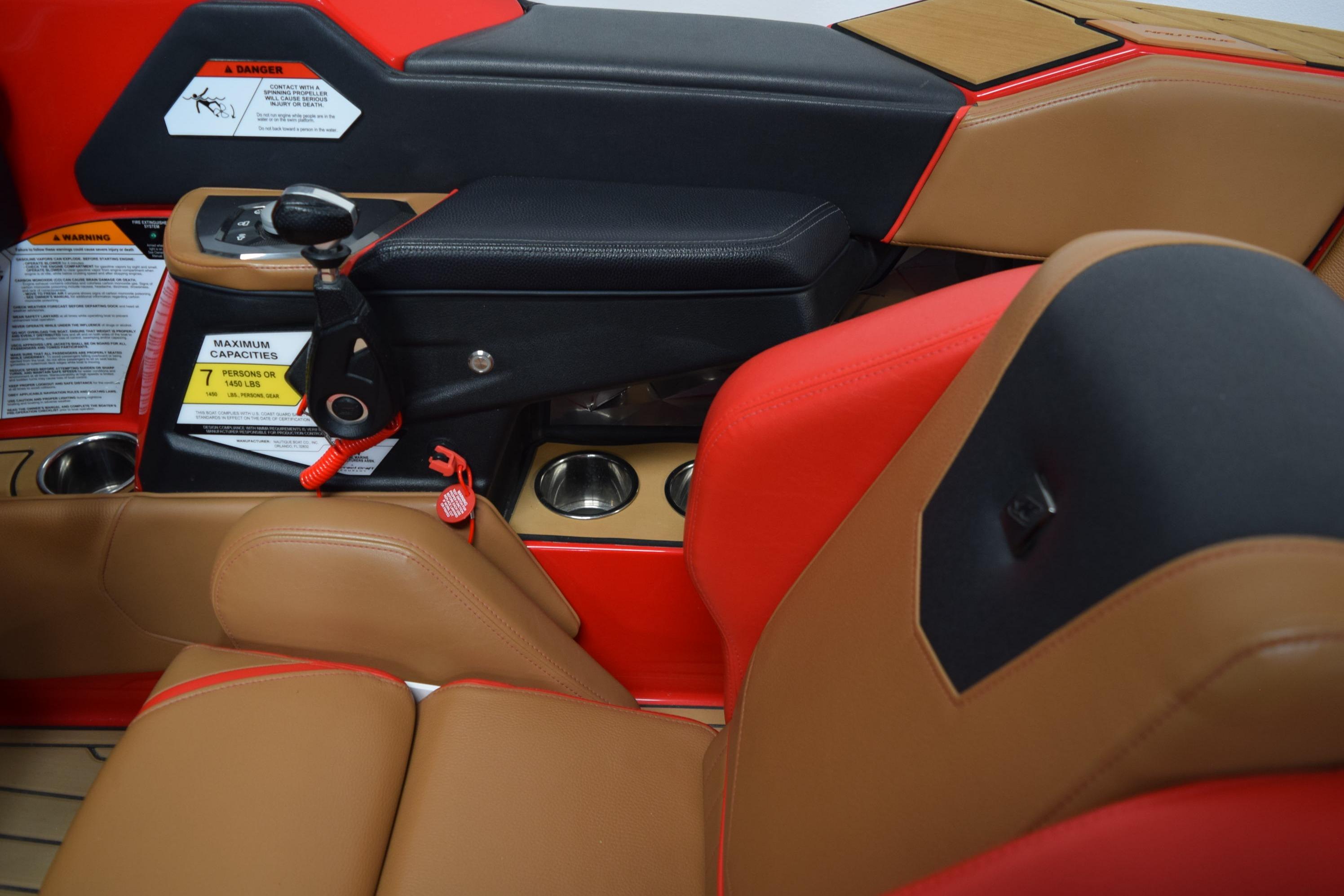2024 Nautique Ski Nautique interior with red and tan seating, cup holders, and control panel.
