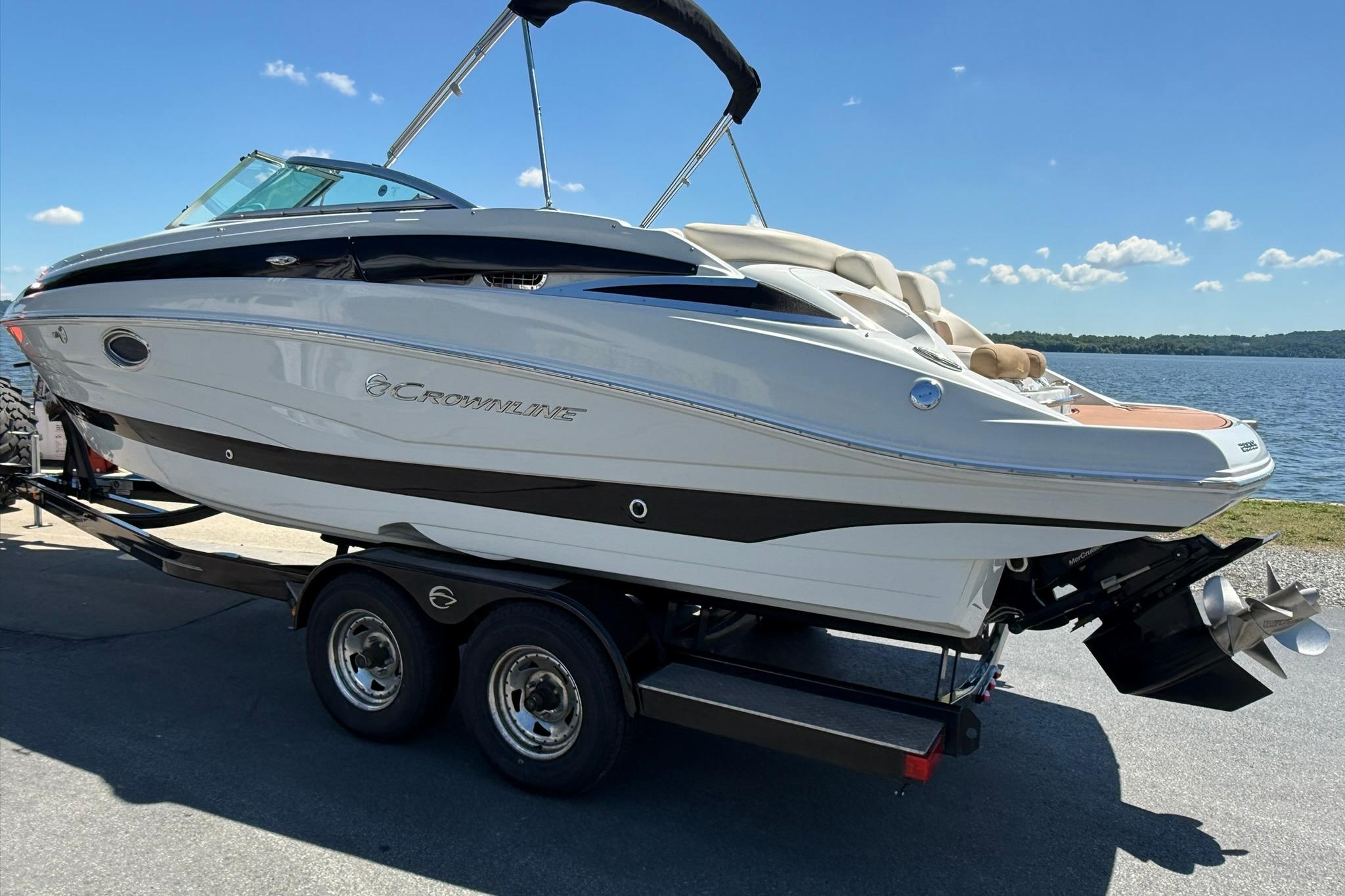 2016 Crownline 255 SS boat on trailer by a lake under clear sky.