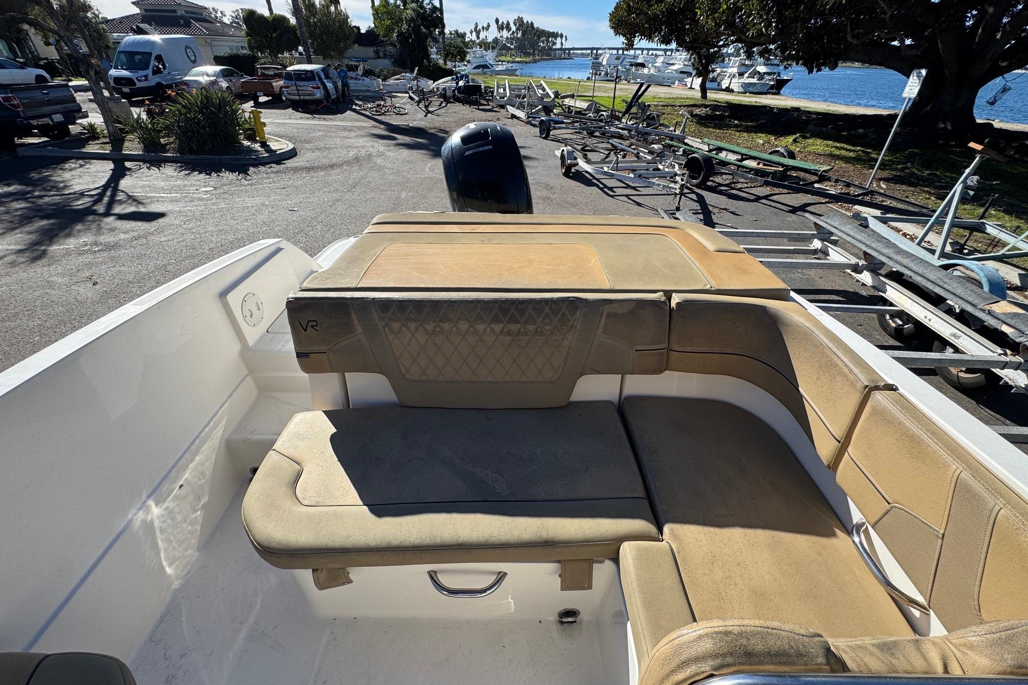 2022 Bayliner VR6 Bowrider OB interior with tan seating, parked near waterfront.