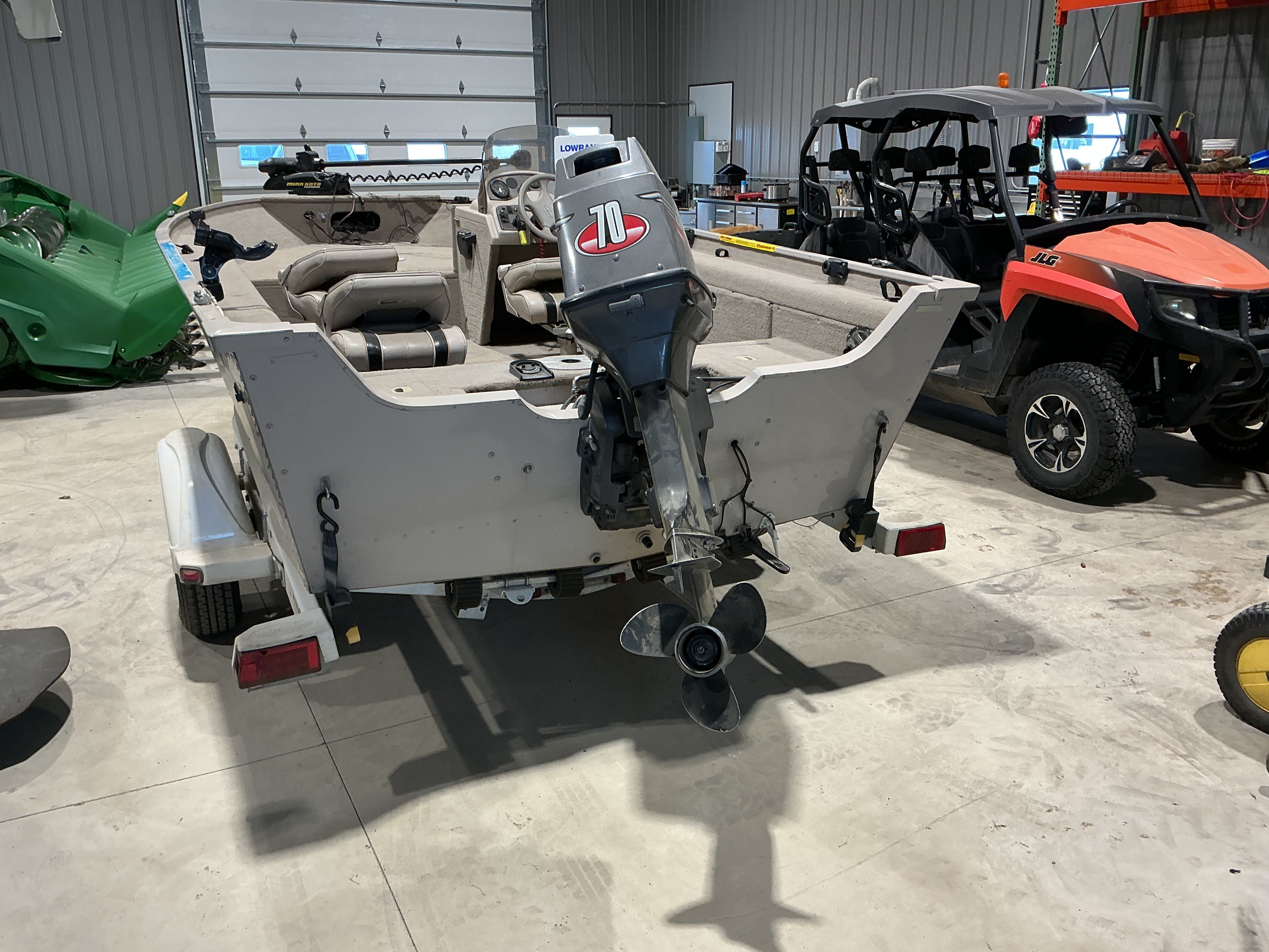 1999 Sylvan EXPEDITION boat with outboard motor in garage.