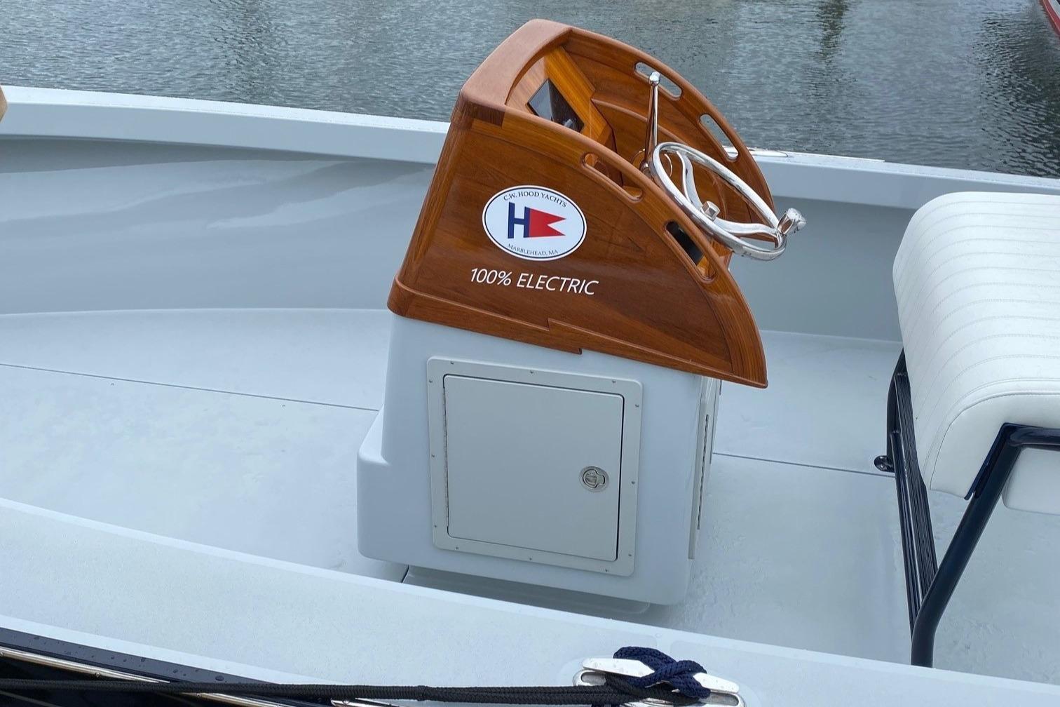 2024 C.W. Hood 26E Electric Runabout with wooden helm and white seating.