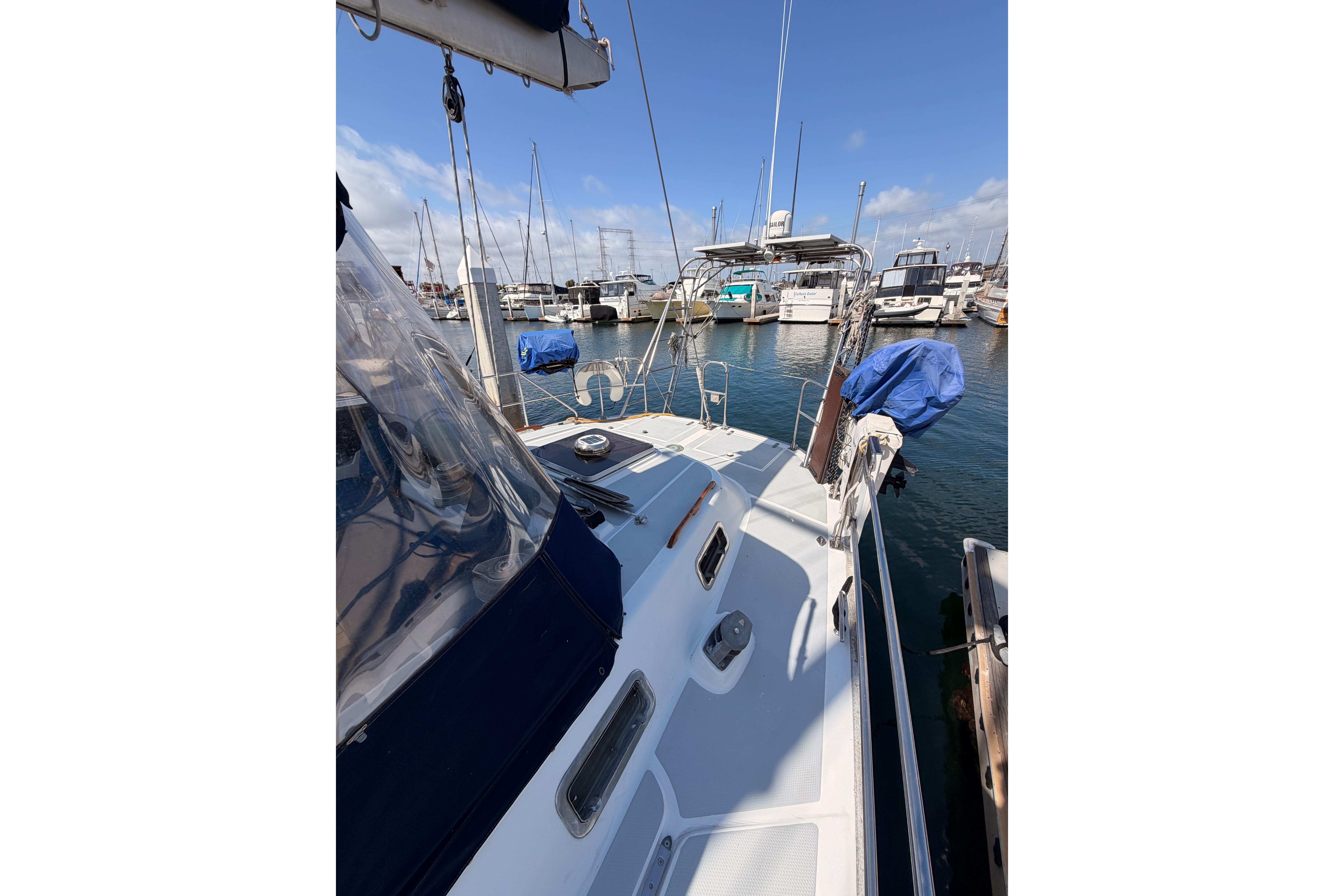 Sailboat Hylas 51, 1991 model, docked in a marina with clear blue skies.