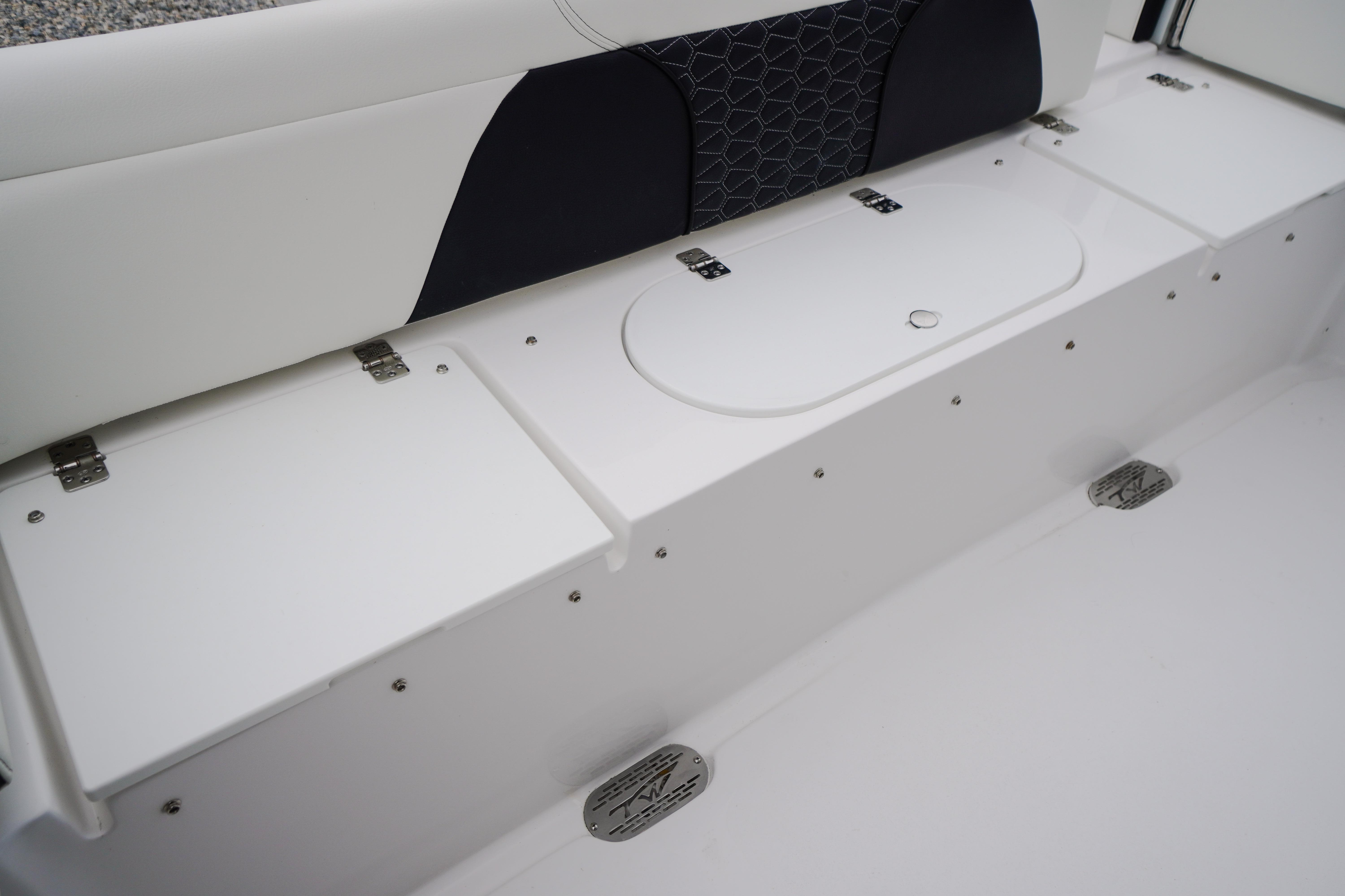 Interior seating and storage of 2026 Tidewater 232 SS boat, featuring sleek white design.