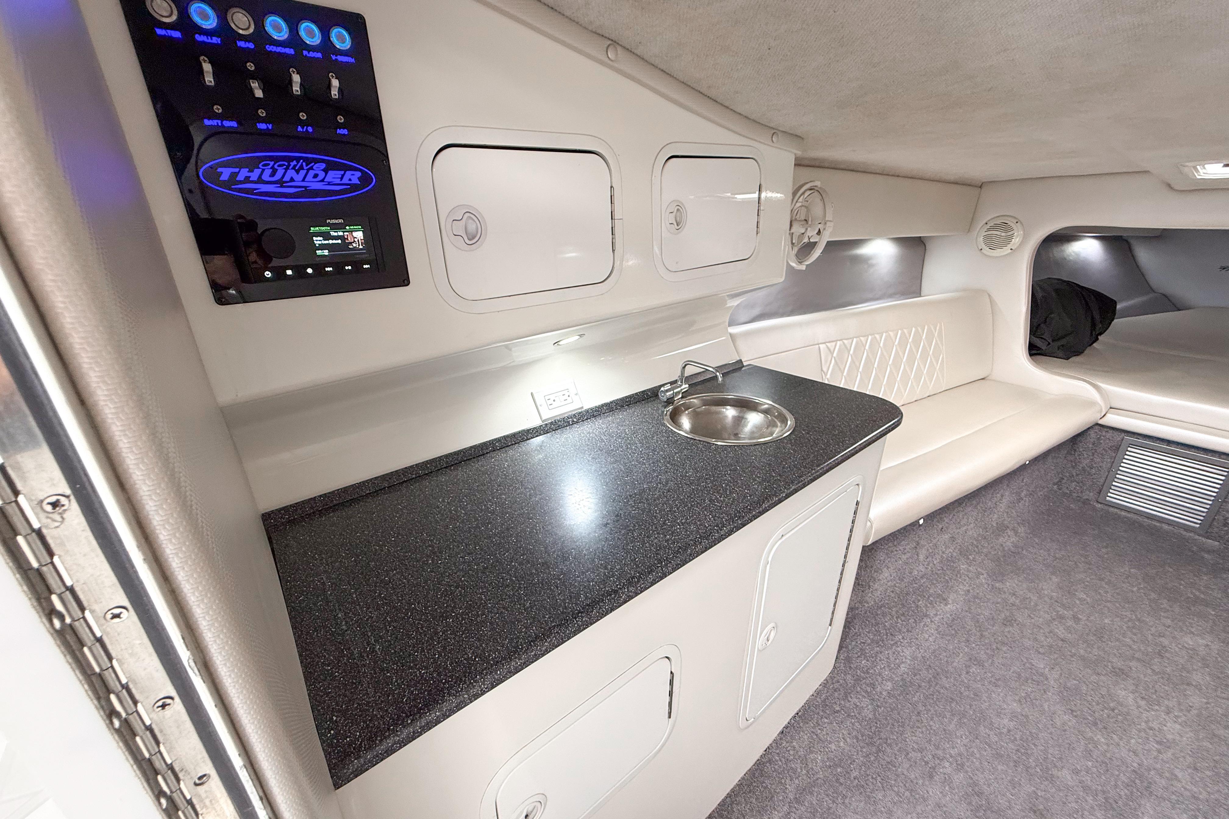 Interior of a 2002 Active Thunder 37 boat featuring a sleek kitchenette and seating area.
