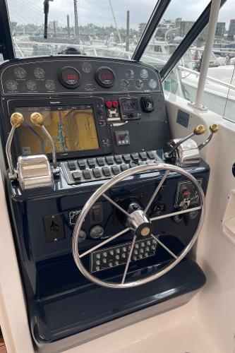 The cockpit of a 2003 Tiara Yachts 3500 Open with steering wheel and navigation system.