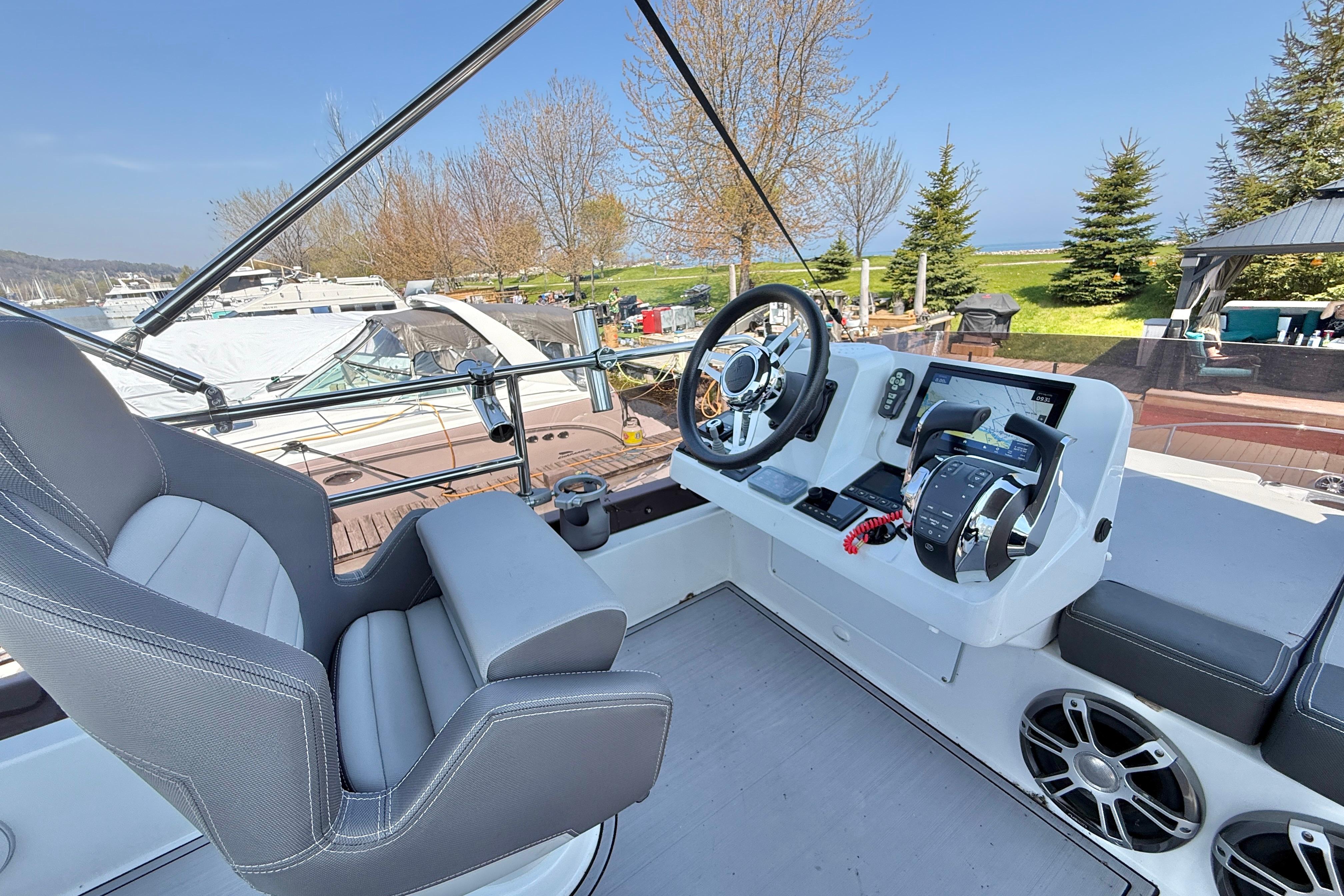 Flybridge helm of 2022 Jeanneau NC 1095 Fly with modern controls and seating.