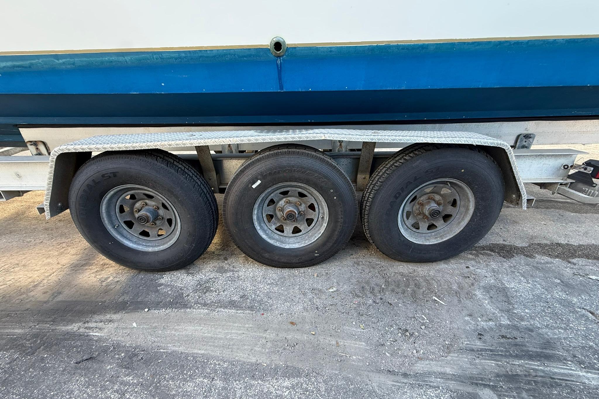 Triple-axle trailer for 1998 Contender 35 Express boat, side view.