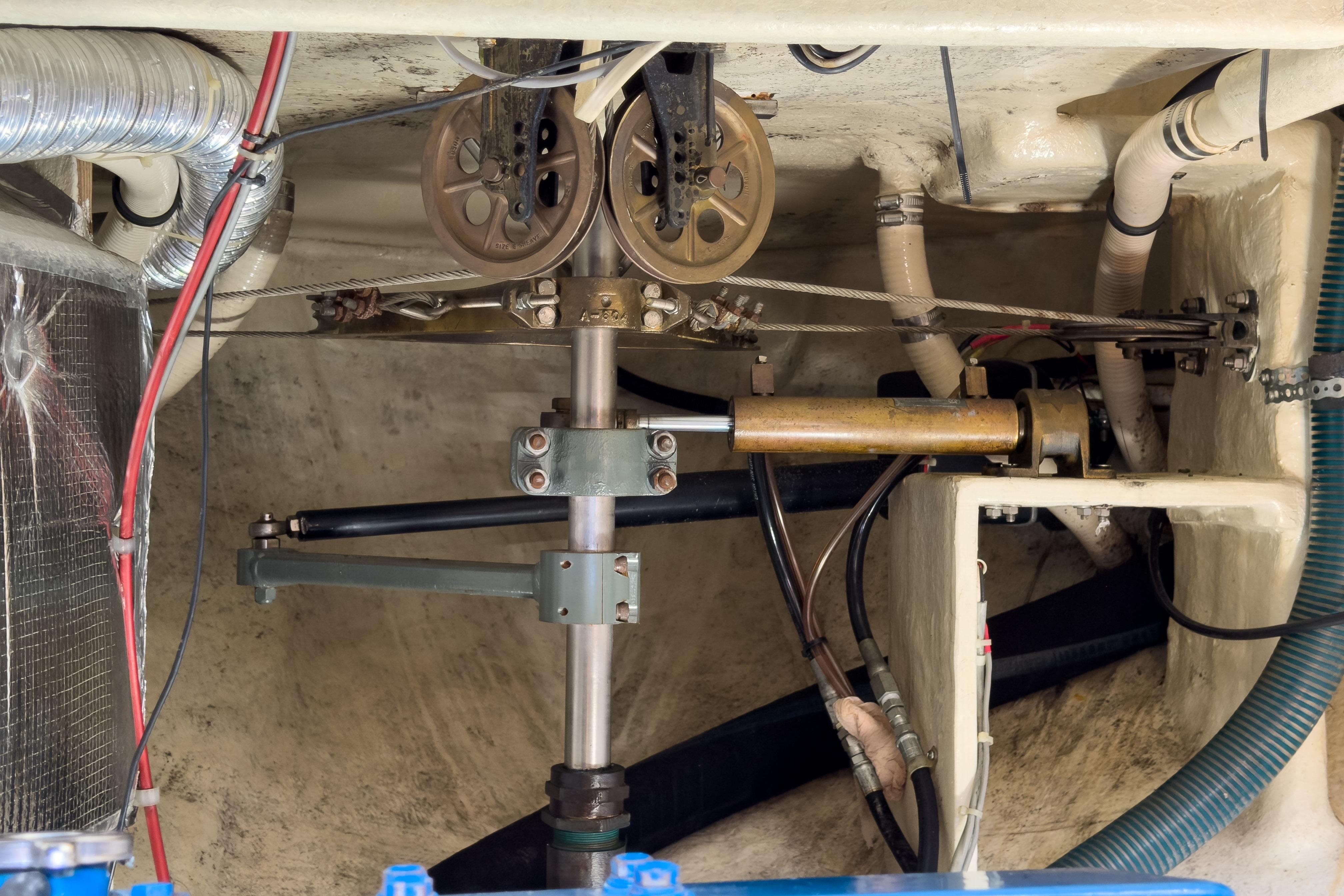 Engine room of a 1983 Corbin 39 sailboat, showcasing mechanical components and piping.