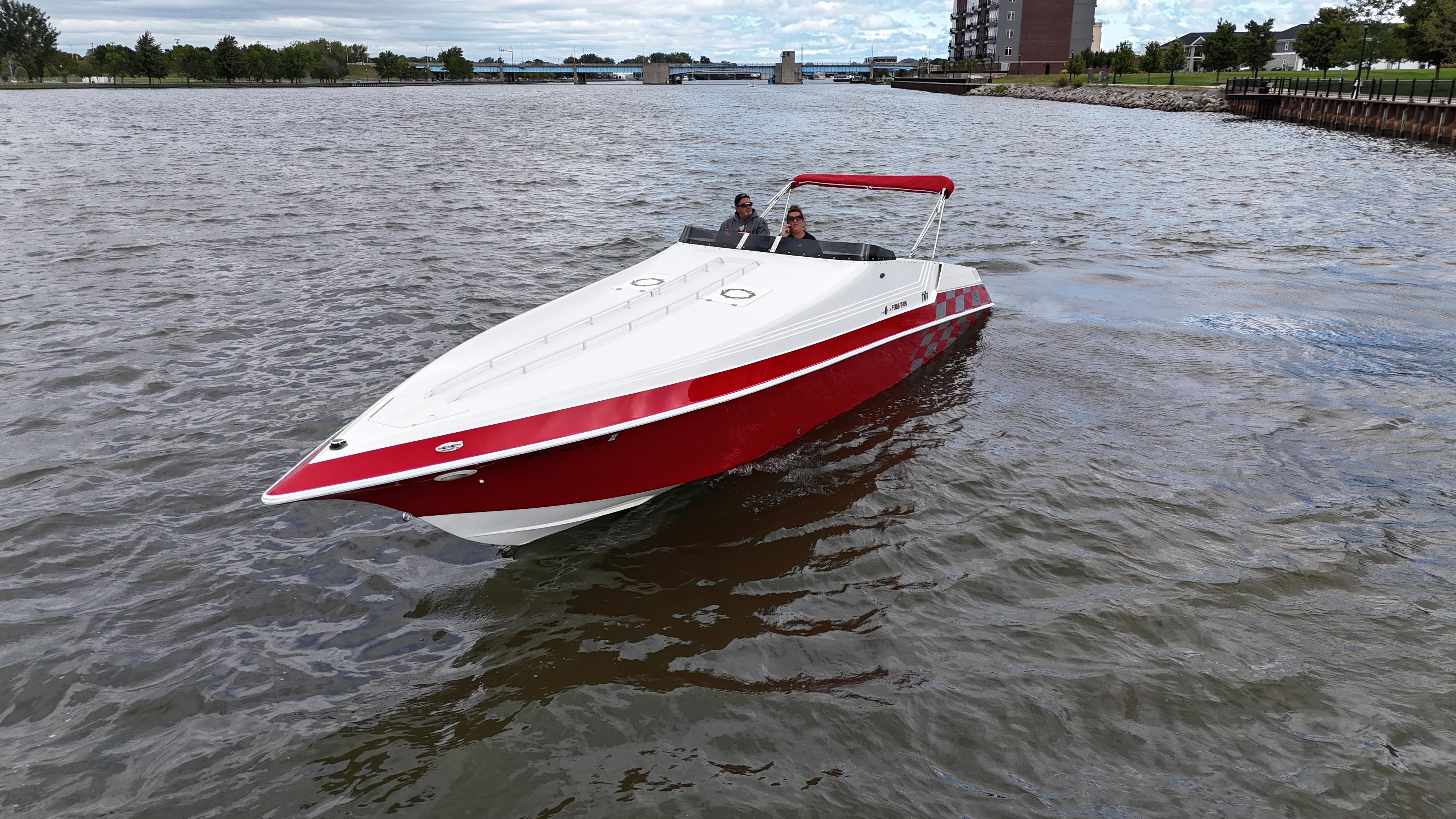1995 Fountain 38 Sport Cruiser boat on a river with red and white design.